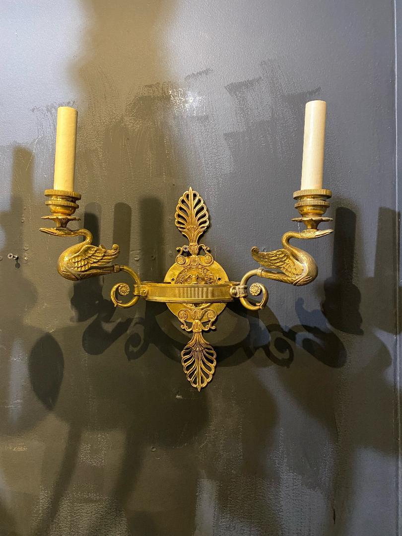 A pair of circa 1930's French Empire bronze sconces with swans and lions head backplate.