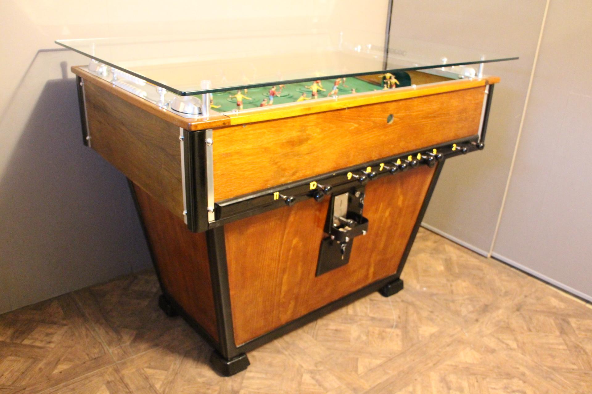 This foosball is very rare because its players spin around on a turning plate to reach the ball.
Green field. Four aluminum ashtrays.
Thanks to its glass top, it could be used as a bar counter or a counter table.
It is an amazing piece and a very