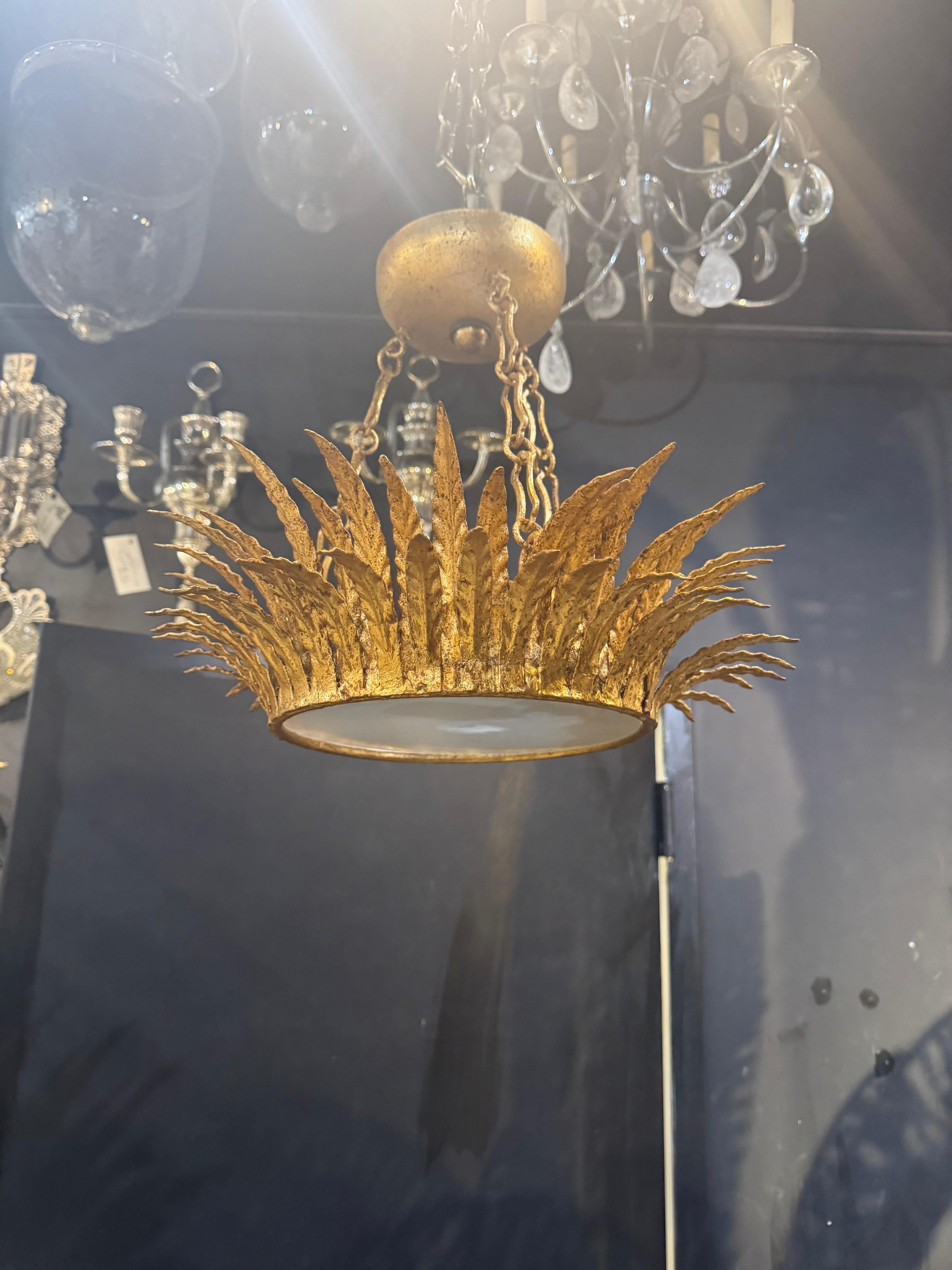 A 1930’s French gilt metal sunburst light fixture with frosted glass inset ,newly UL rewired