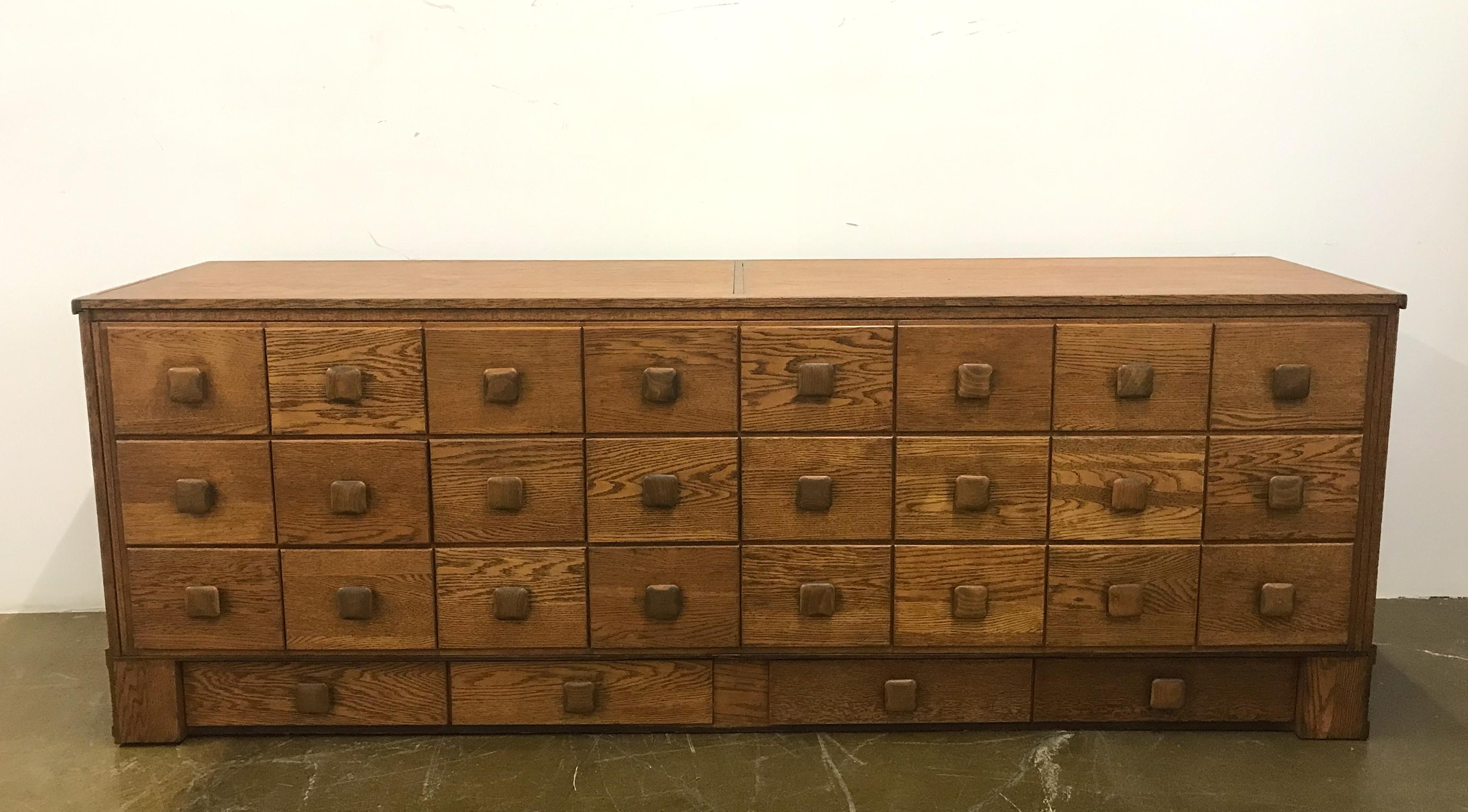 Great looking, oak display counter or storage cabinet for mens' clothing from a French haberdashery. There are a total of 28 drawers, all dovetailed and working beautifully. Each drawer has a masculine square wooden pull.
This used to have glass