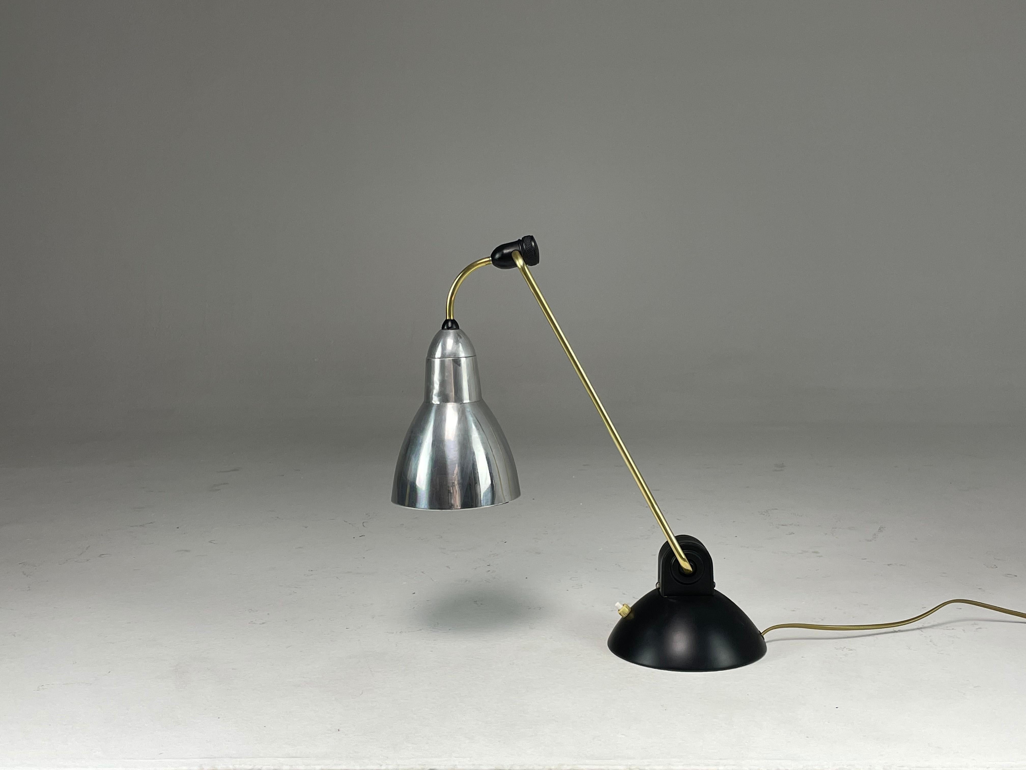 A striking French 20-century vintage desk or table lamp composed of aluminum, steel and brass. The base features a push-type switch and the light rotated and the base and shade. 
The base was restored with new black lacquer. 
Professionally