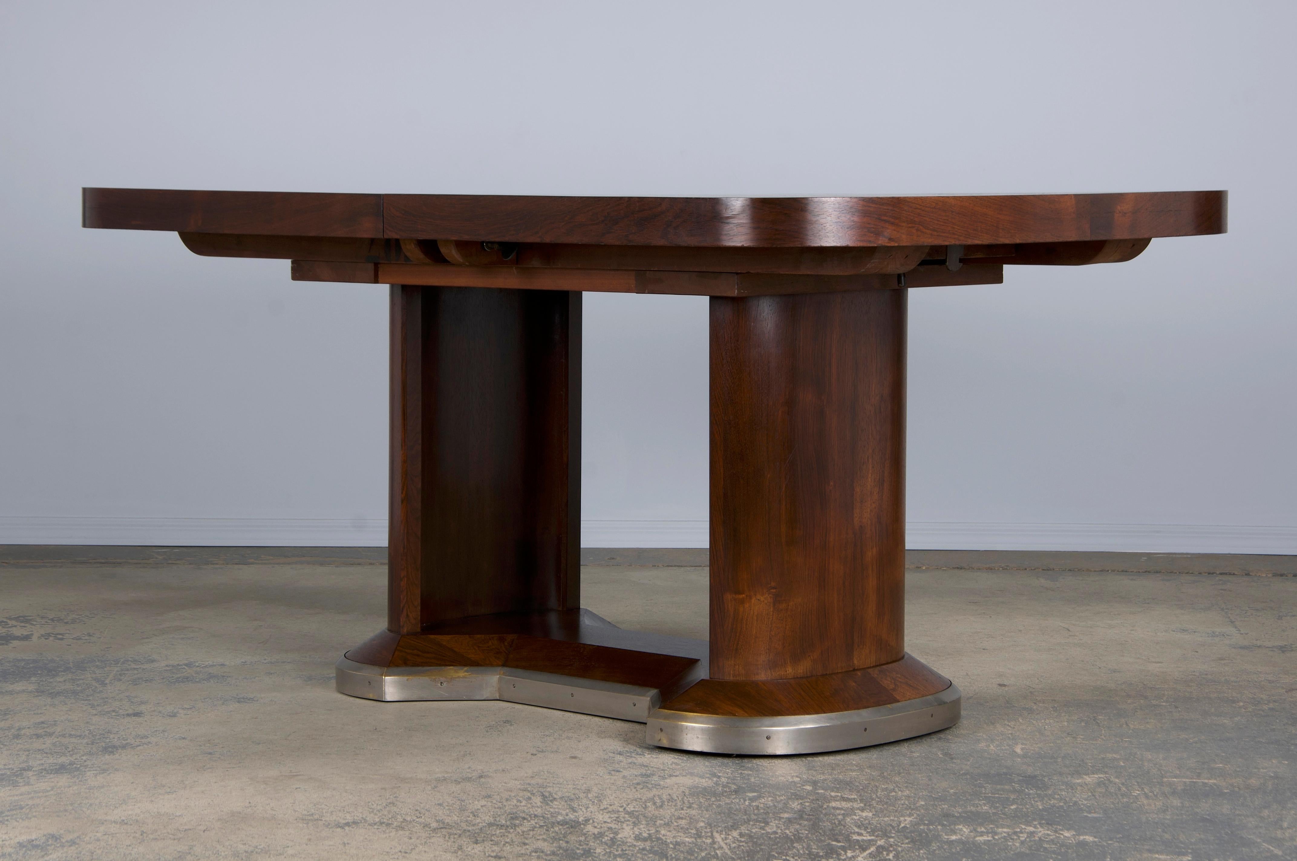 An elegant 1930s French dining table attributed to Jules Leleu, sourced from Paris, France. Expertly hand-crafted from rosewood, it boasts a naturally aged patina that enhances its rich brown tone and striking grain. The table features a 5'1