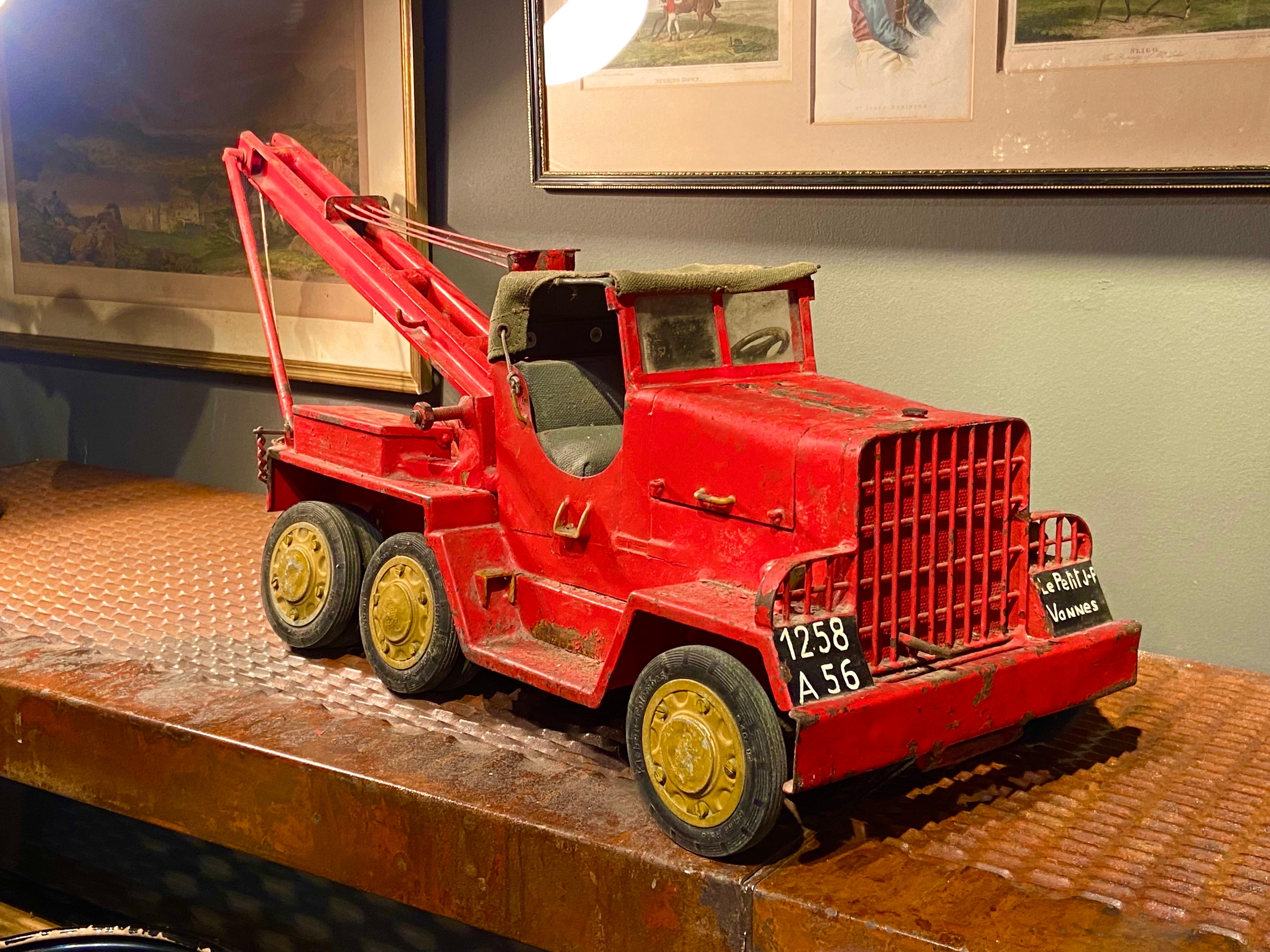 Large toy tow truck made in red lacquered metal with nice details and opening compartments.
France, circa 1930.