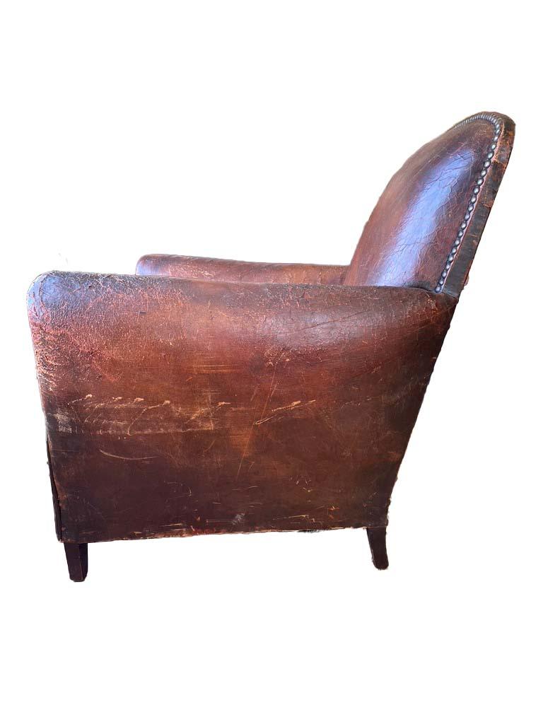 beautiful 1930s French leather club chair with original leather and railheads. The seat has been reupholstered with a vintage burchell zebra hide and the decking has been retained and is a wonderful striped fabric. The leather is worn and aged and