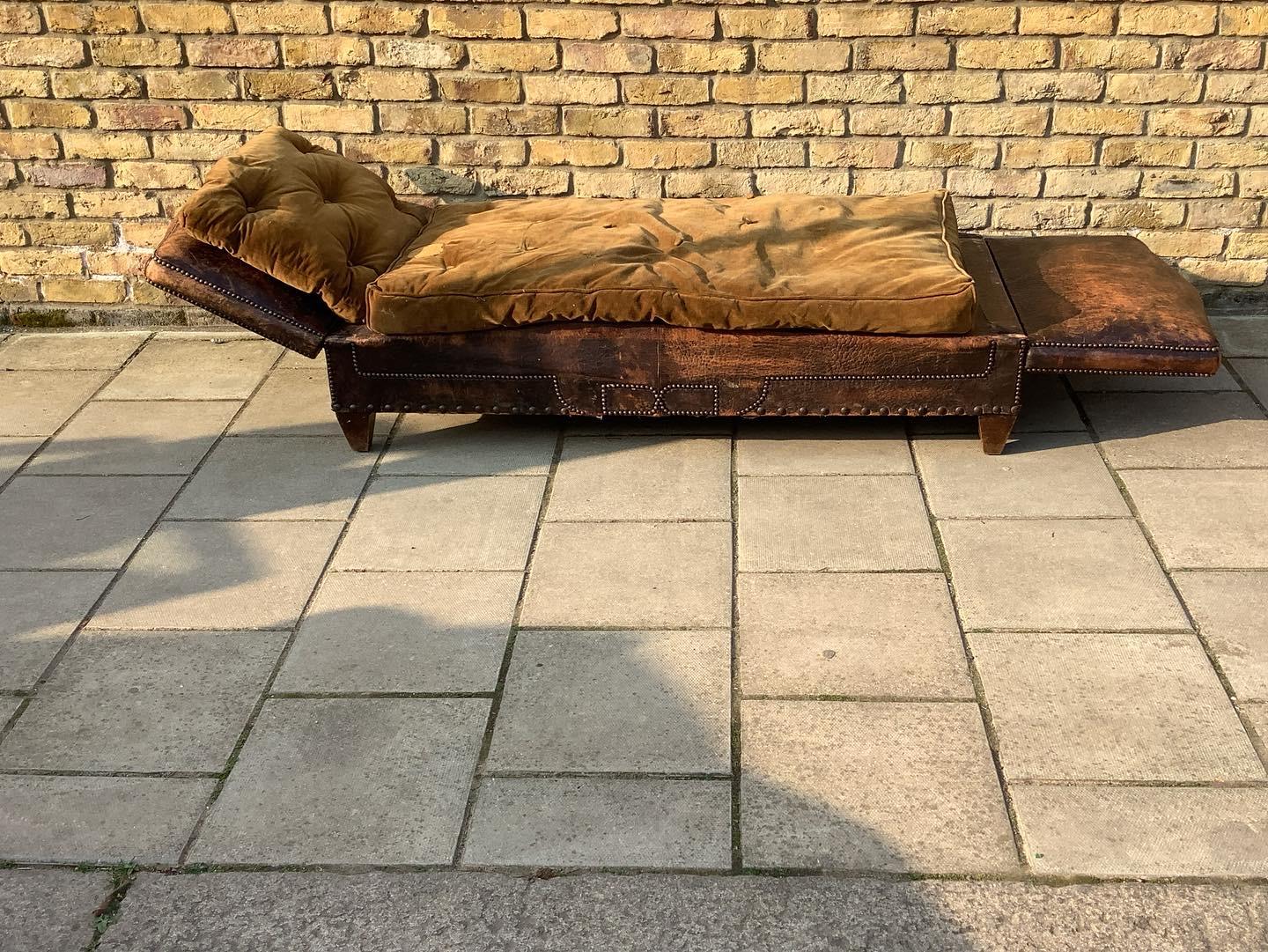 Handsome French leather daybed, with both arms that can drop fully flat. Lovely colour and condition to the leather, brass studding to perimeters, and wonderful 
Wooden legs. All original in colour and condition. Quite rare to find this condition
