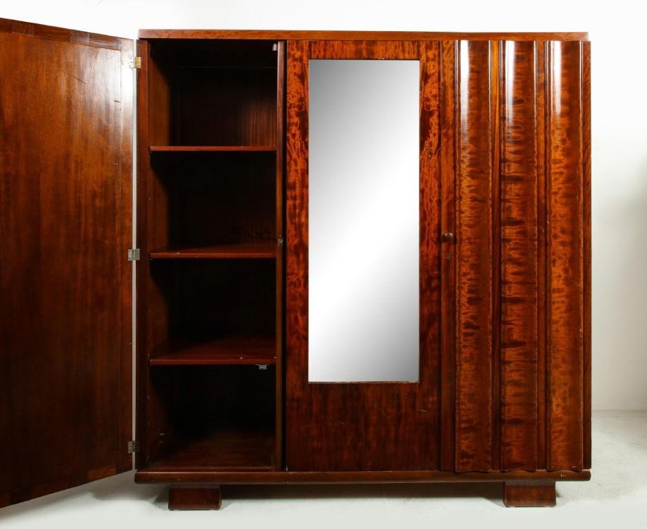 High gloss French mahogany burl wood armoire with mirror, c. 1930. Fluted panel doors cover shelving on either side of the mirror. Magnet closures.