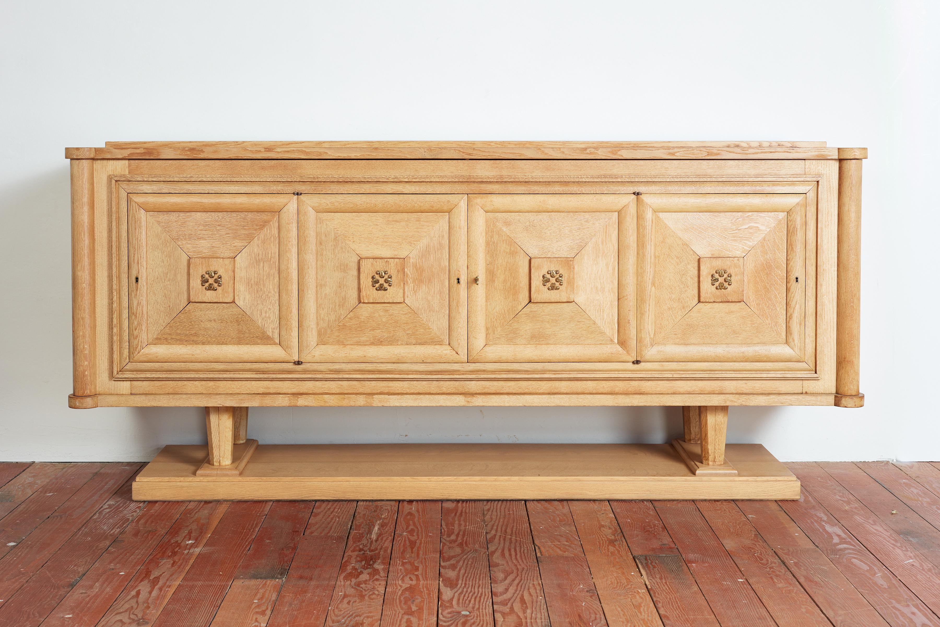 Riesiges Sideboard aus französischer Eiche mit schöner Patina und dekorativen Bronzebeschlägen.
Frankreich, 1930er Jahre
Vier Türen lassen sich öffnen und geben den Blick auf offene Regale und Schubladen frei