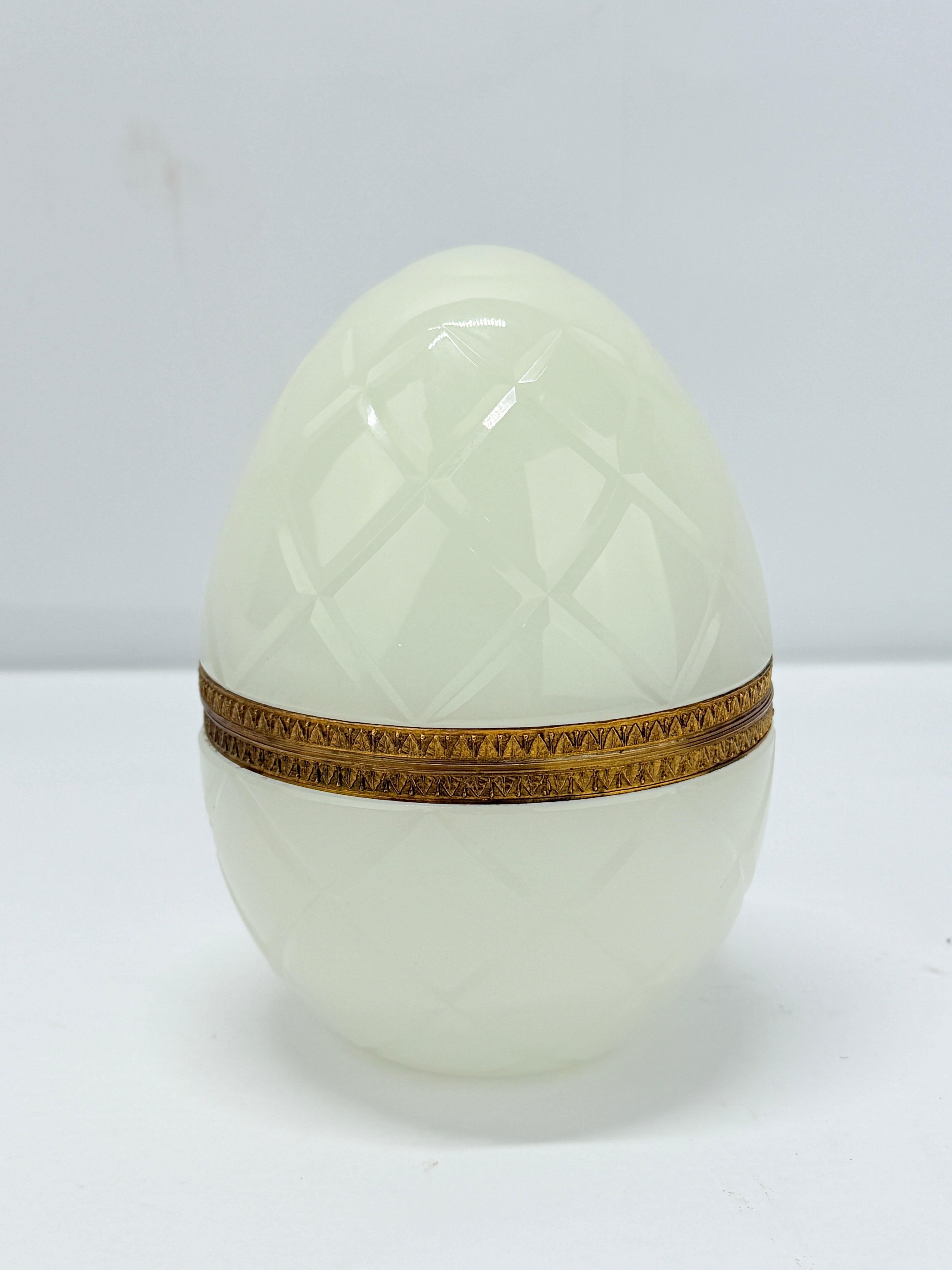 French, 1930's.
An antique French blue opaline glass egg trinket box. This larger sized egg has a hinged design with foliate engravings to the ormolu band. Unmarked.

Measures:
6