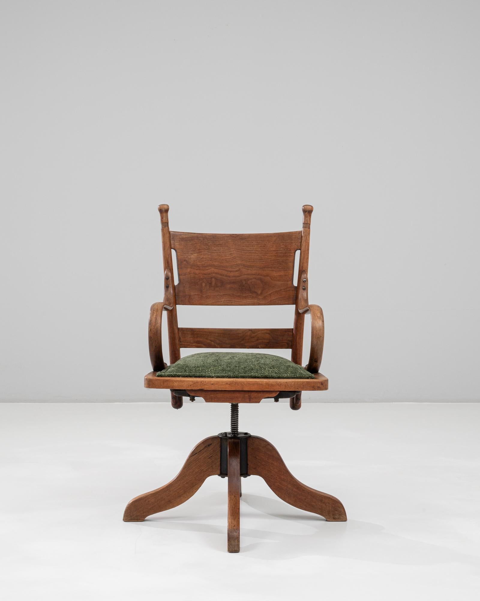 Ce fauteuil pivotant en bois français des années 1930 allie la fonctionnalité de l'ère industrielle à la chaleur et au savoir-faire du design du début du XXe siècle. Les accoudoirs légèrement incurvés, le dossier profilé et le cadre en bois massif
