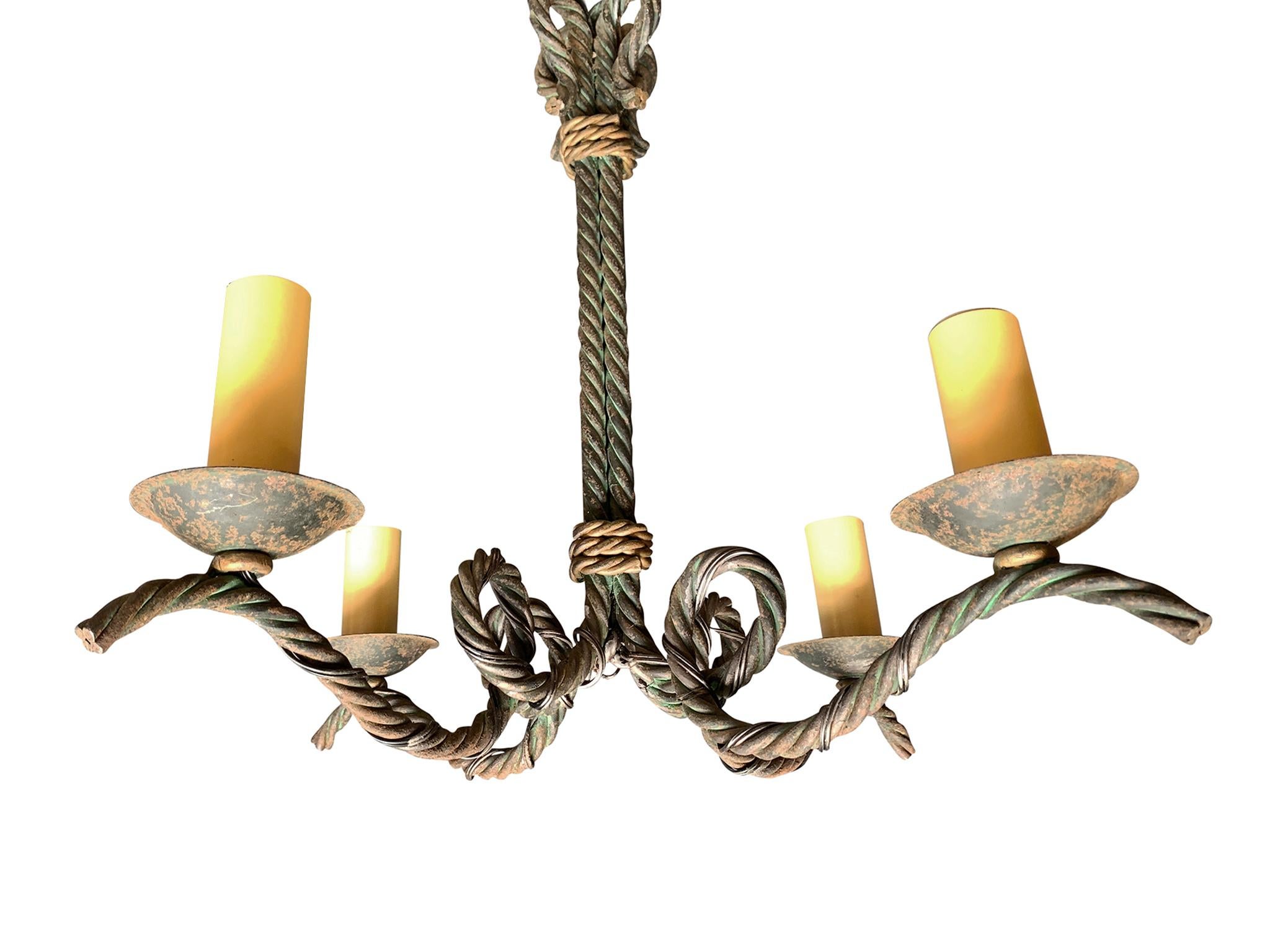This 1930s French chandelier has an elegant twist rope design constructed with wrought iron. It has 4 candelabra arms, each culminating with a single bulb socket. The chandelier has been rewired and has new candle-style socket