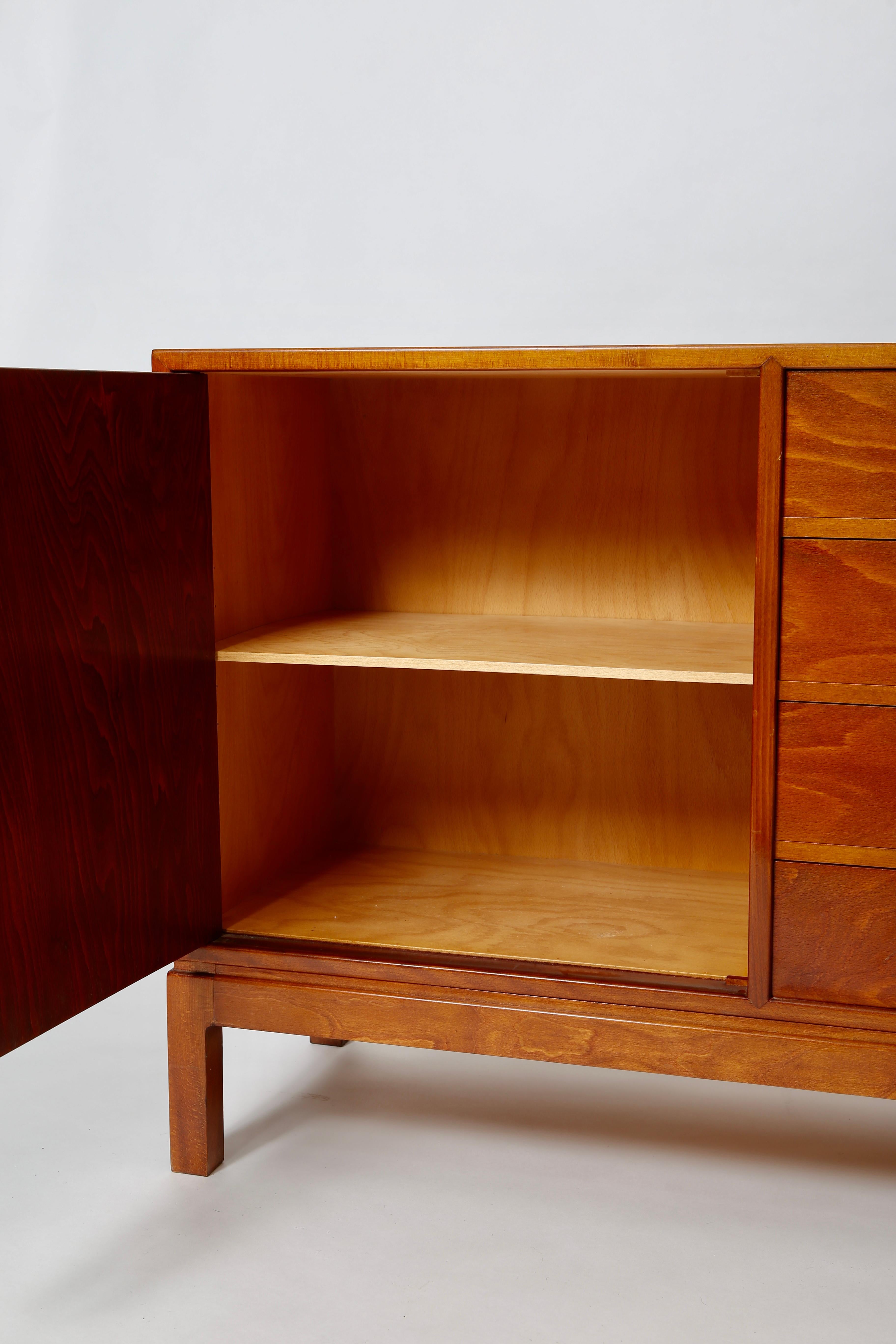 A stately sideboard in stained beech with lovely brass hardware. Designed and produced 1930s Denmark by Fritz Hansen, this cabinet is labeled to reverse side. 
All original finish with age-appropriate signs of use. Cabinet doors open at each side