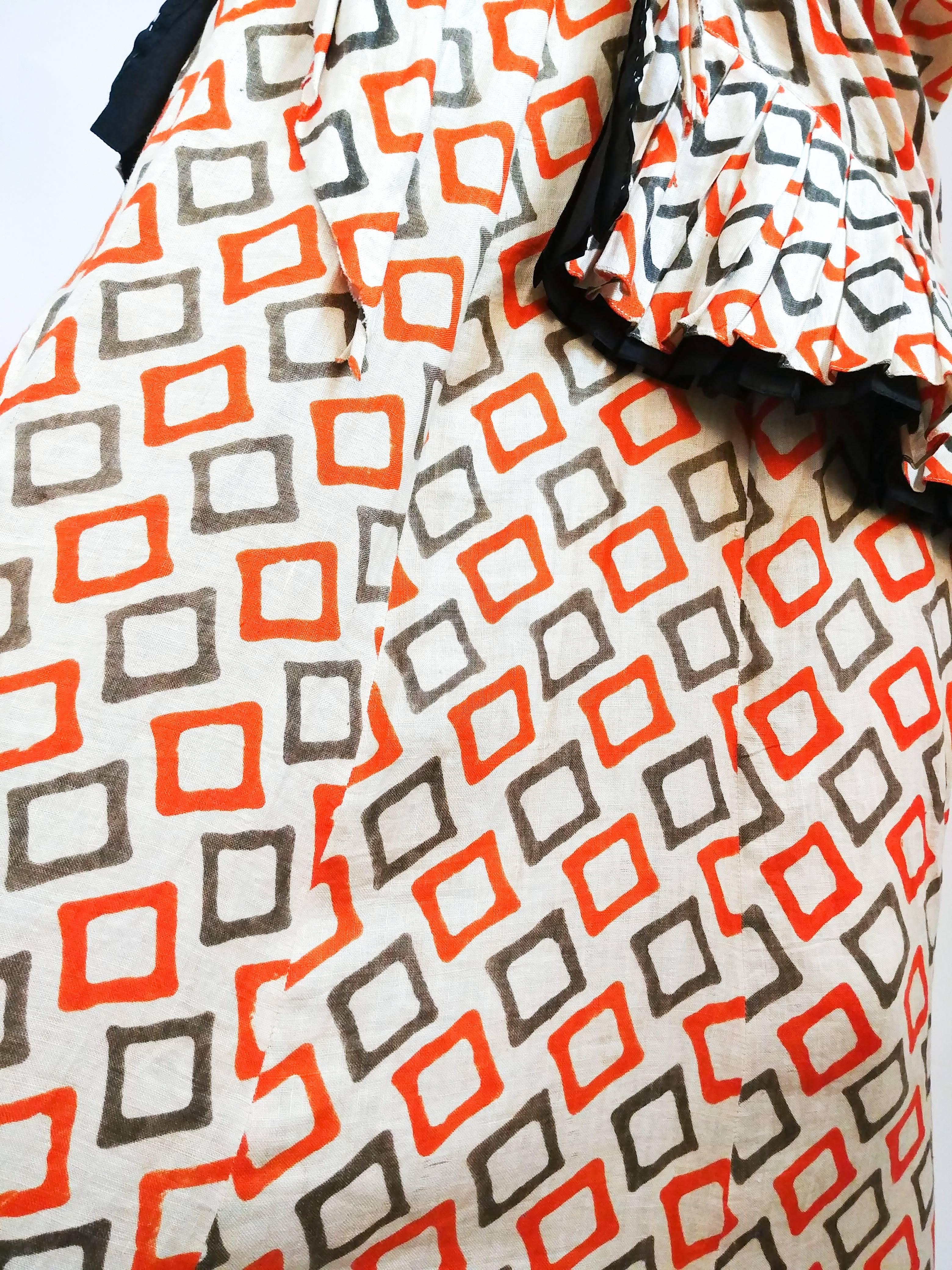 1930s Geometric Printed Cotton Dress. Orange and grey novelty print full-length dress with faux sarong wrap at waist and pleated ruffled detail at bust. 