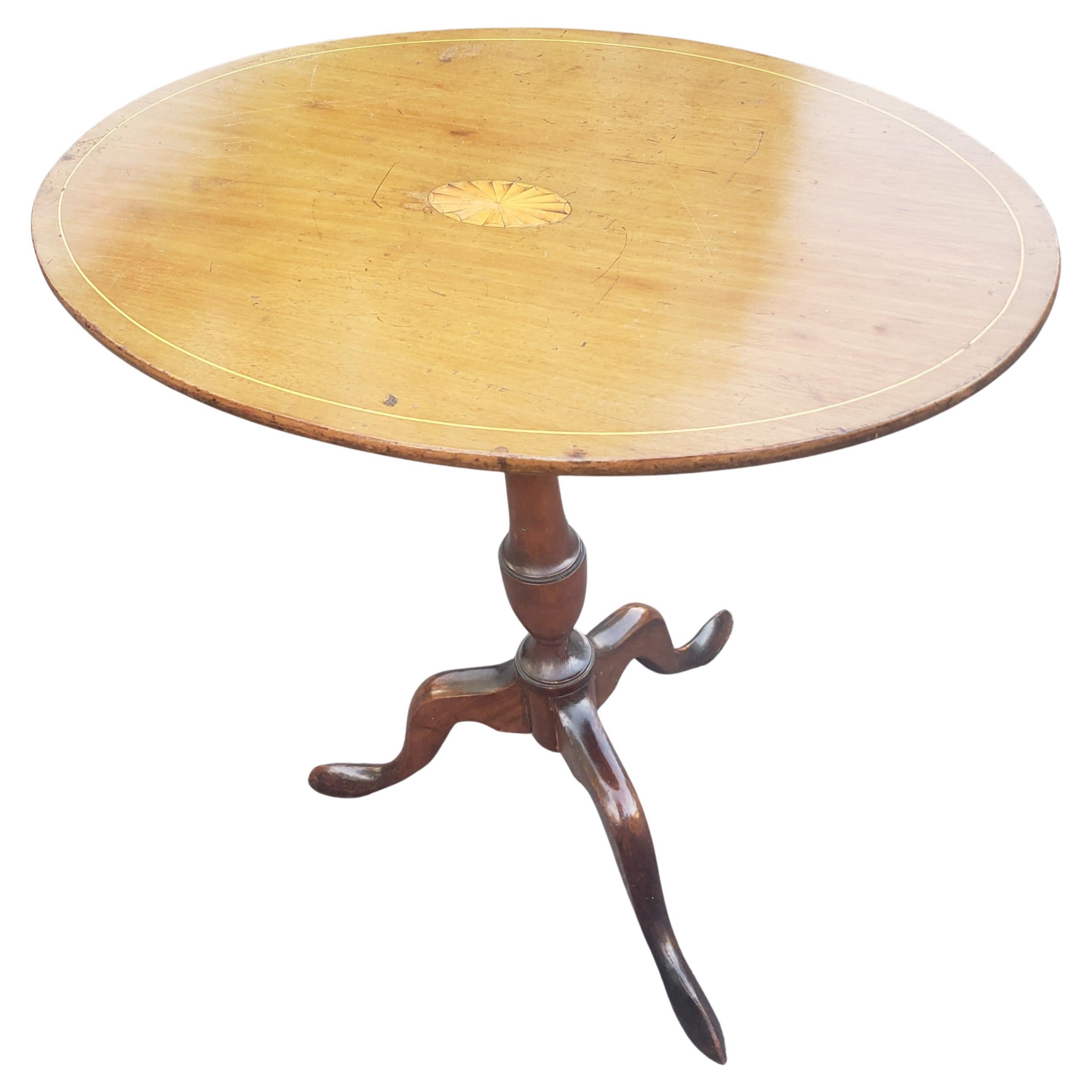 A 1930s Georgian style Mahogany and Satinwood Inlaid oval tilt-top side table on pedestal tripod and terminating with snake feet.
Measures 24