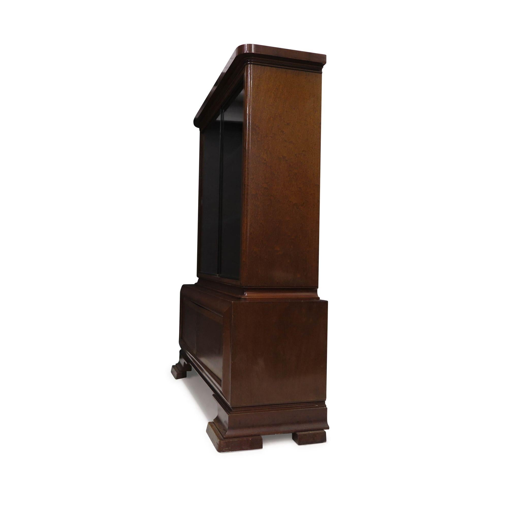 1930s German Art Deco Cabinet crafted from walnut, featuring a pair of sliding glass doors and adjustable shelves, above a cabinet with locking doors. The piece retains its original finish and is in good condition with age-appropriate