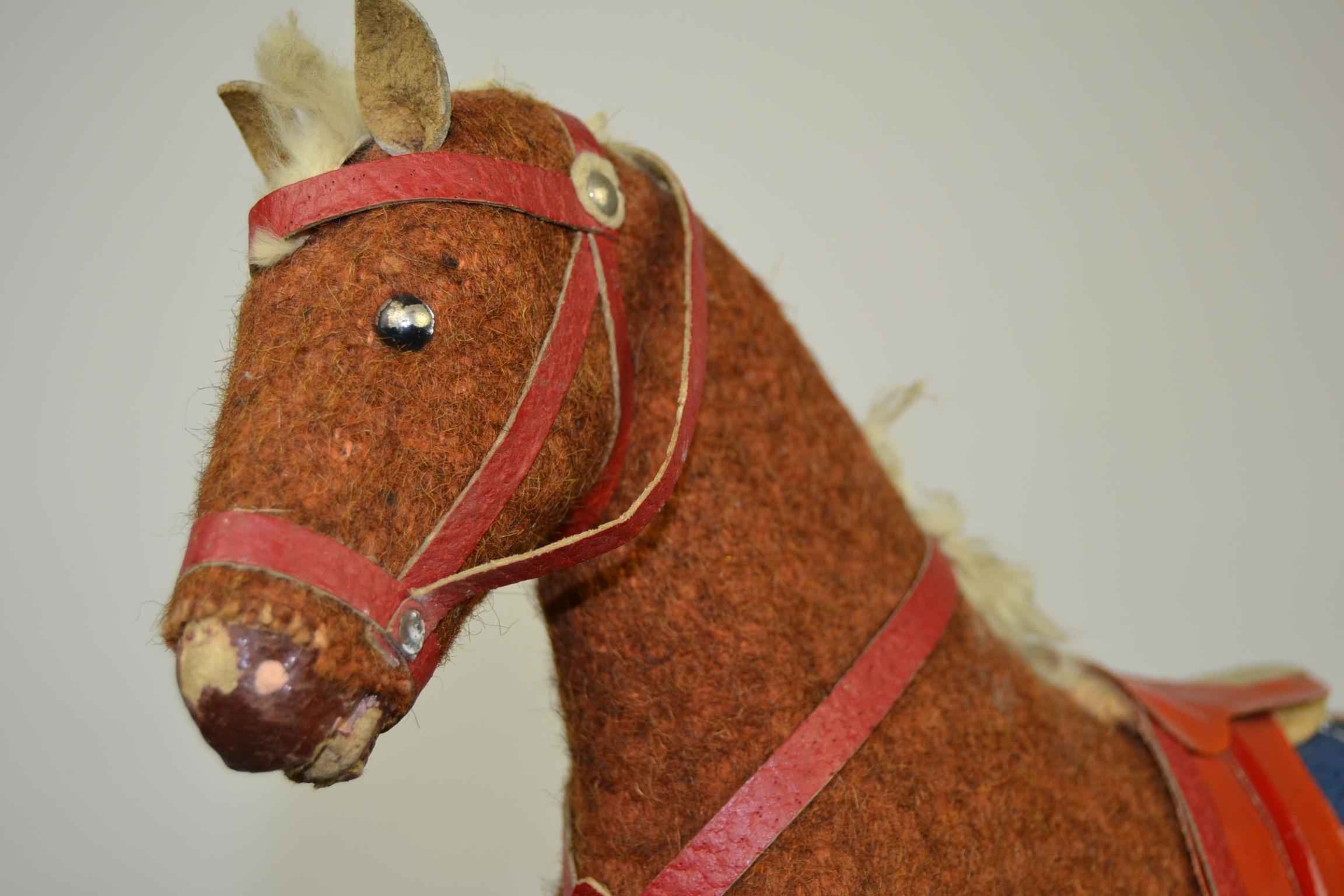 Beautiful antique German toy, a pull toy, a pull horse toy.
This antique toy horse, circa 1930s, is mounted on a wooden platform with wheels. The carved wood horse is covered with rustic brown burlap.
The hooves and snout are also hand carved and