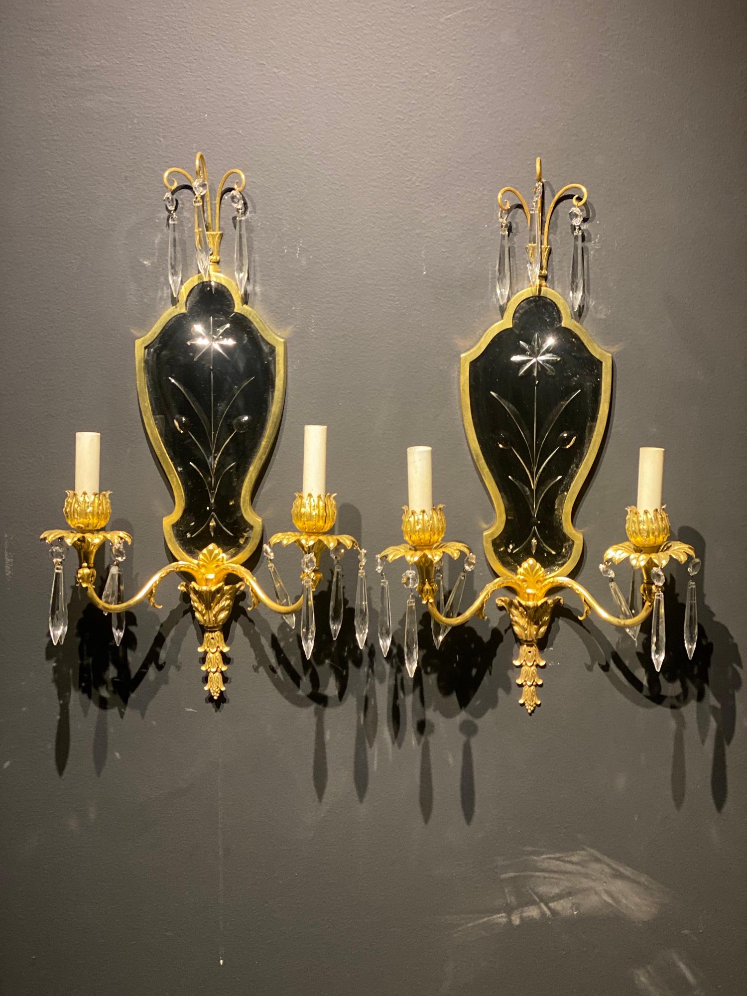 A pair of circa 1930’s Gilt bronze sconces with etched mirrored backplate and crystals hangings 