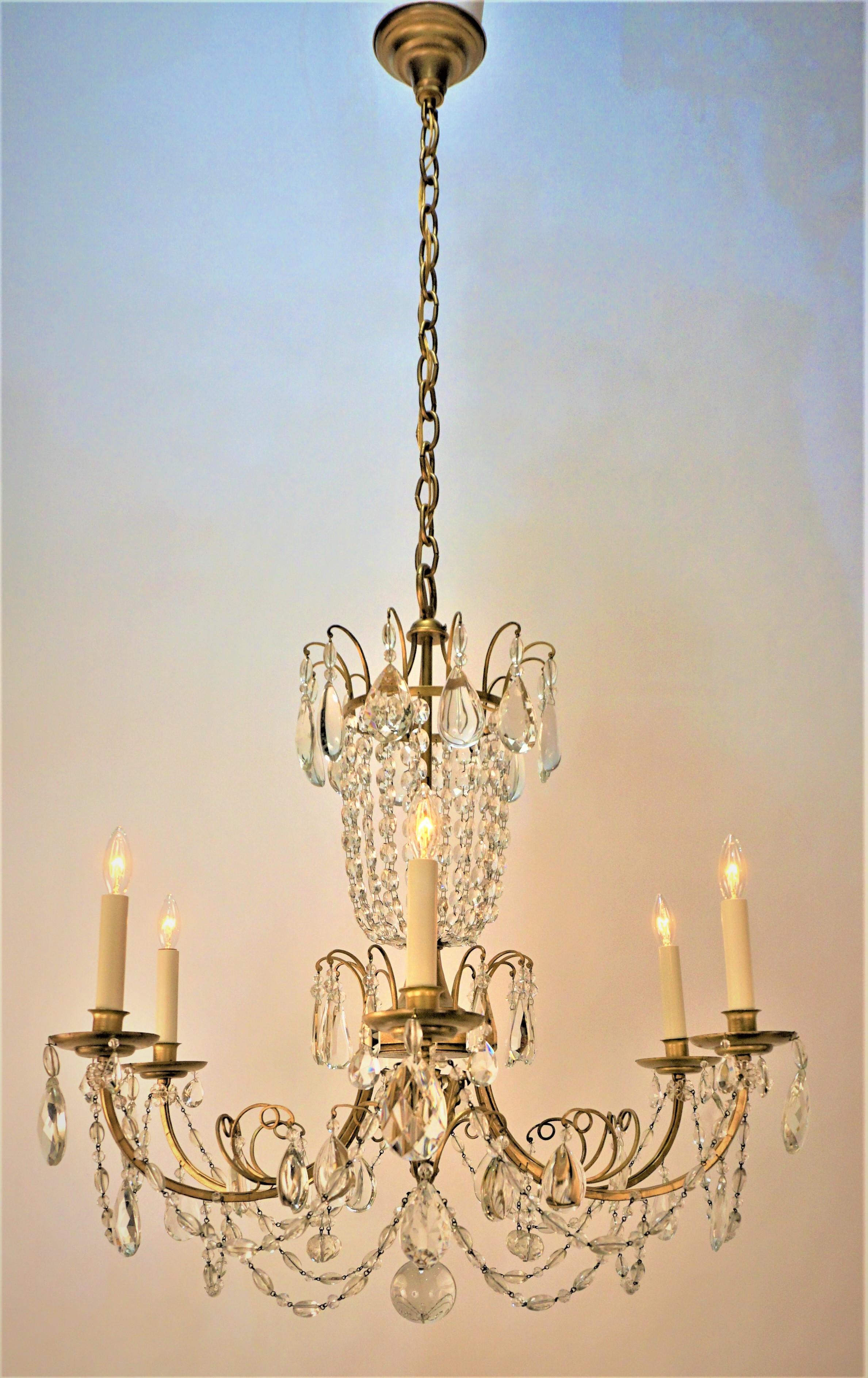 Lustre français à six bras en fer doré et cristal à facettes des années 1930
75 watts maximum par lampe.
Mesures : largeur 29