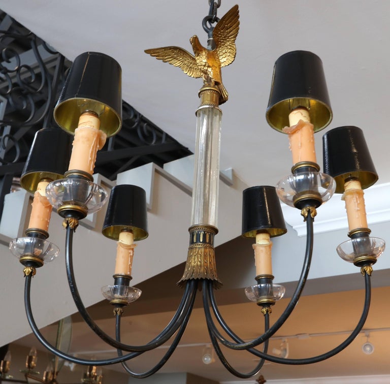 1930s imperial style chandelier with clear glass rod and black metal arms and bronze eagle finial with six wax candle-like lights.