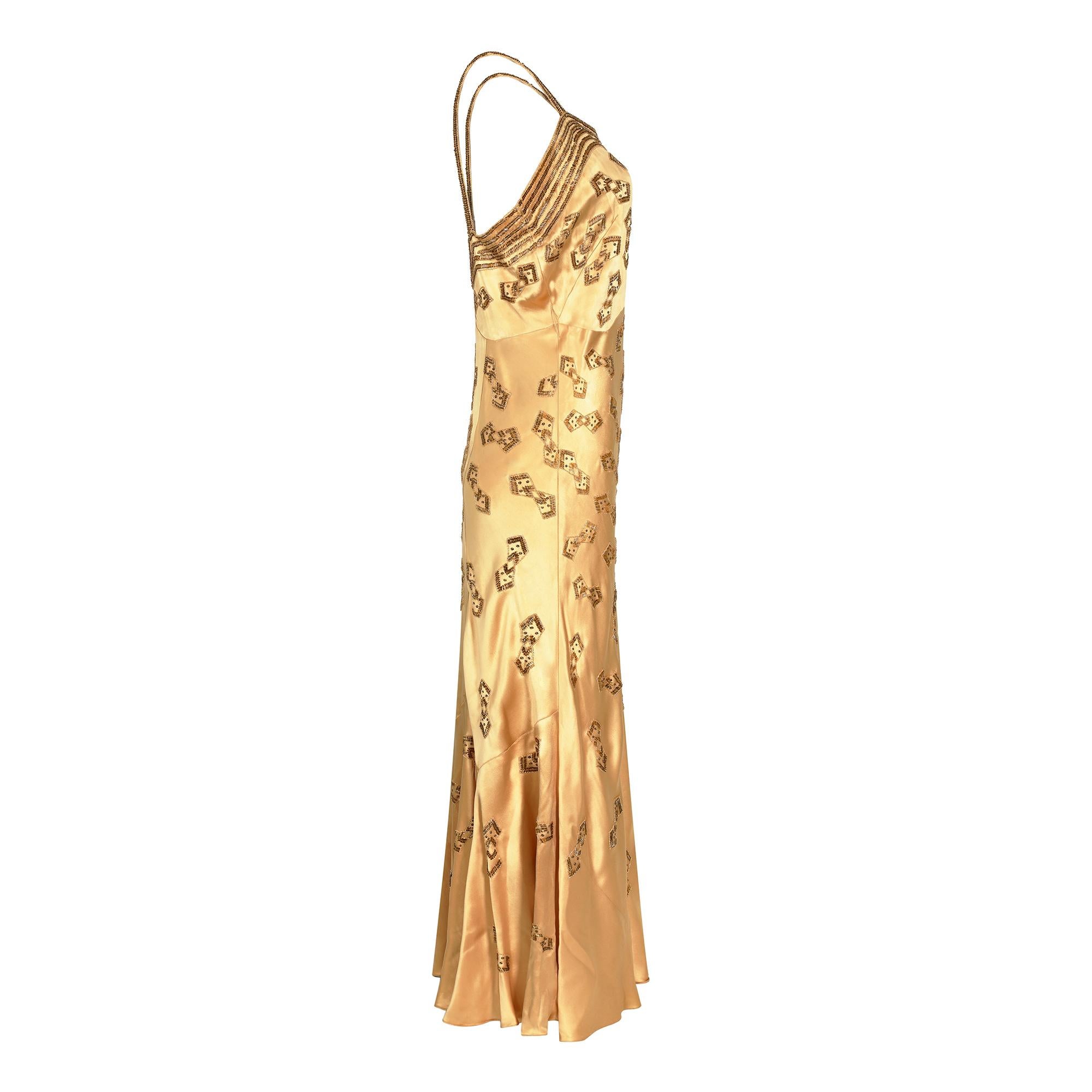 A very eye catching original Art Deco beaded and sequinned dress in extraordinary condition for its age. The exquisite angled 'bow tie' design is repeated all over the dress and the rich embellishment complementary against the warm gold coloured