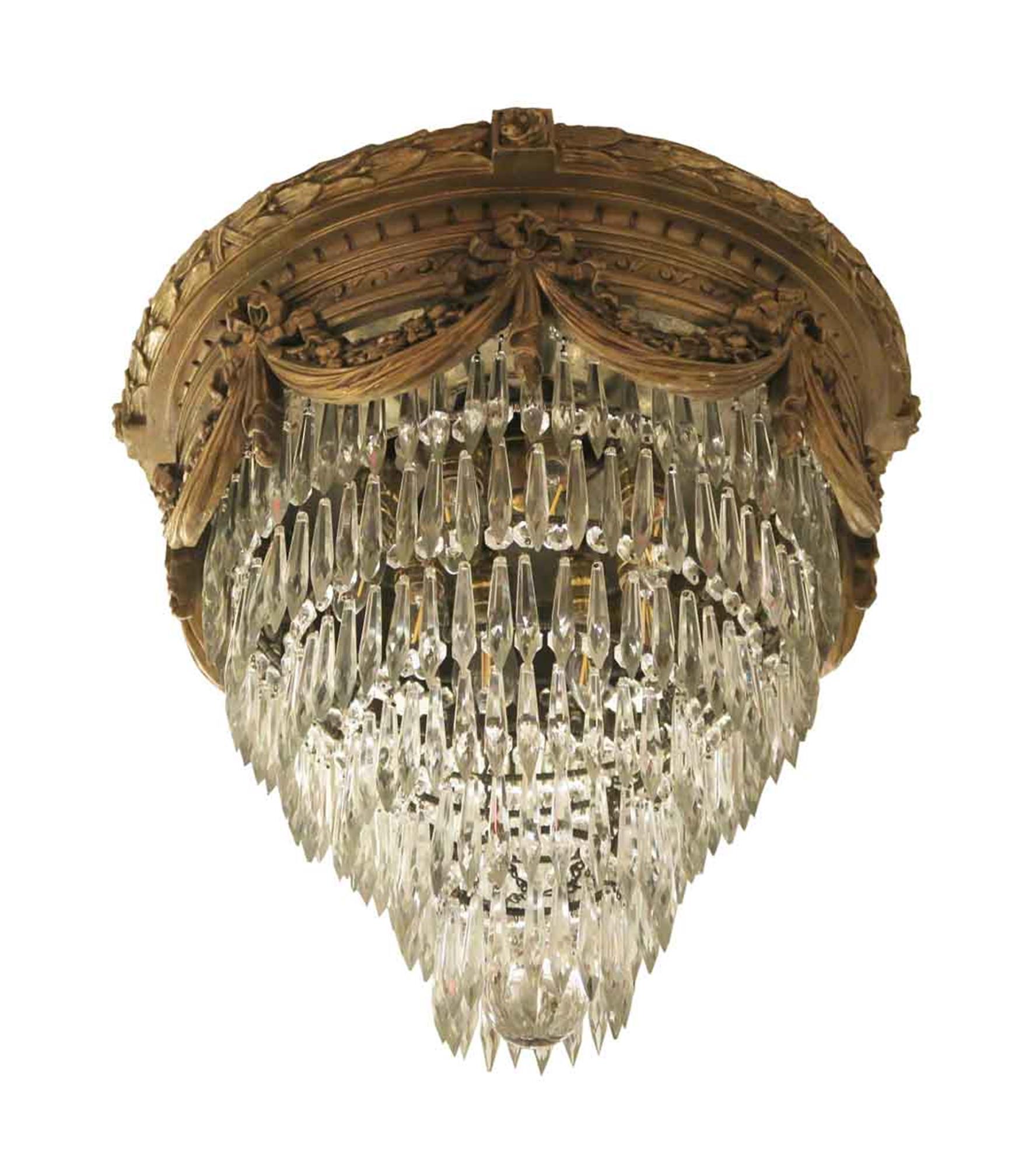 1930s clear crystal wedding cake style flush mount light with a decorative gold gesso frame. This light has been completely restored. This can be seen at our 2420 Broadway location on the upper west side in Manhattan.