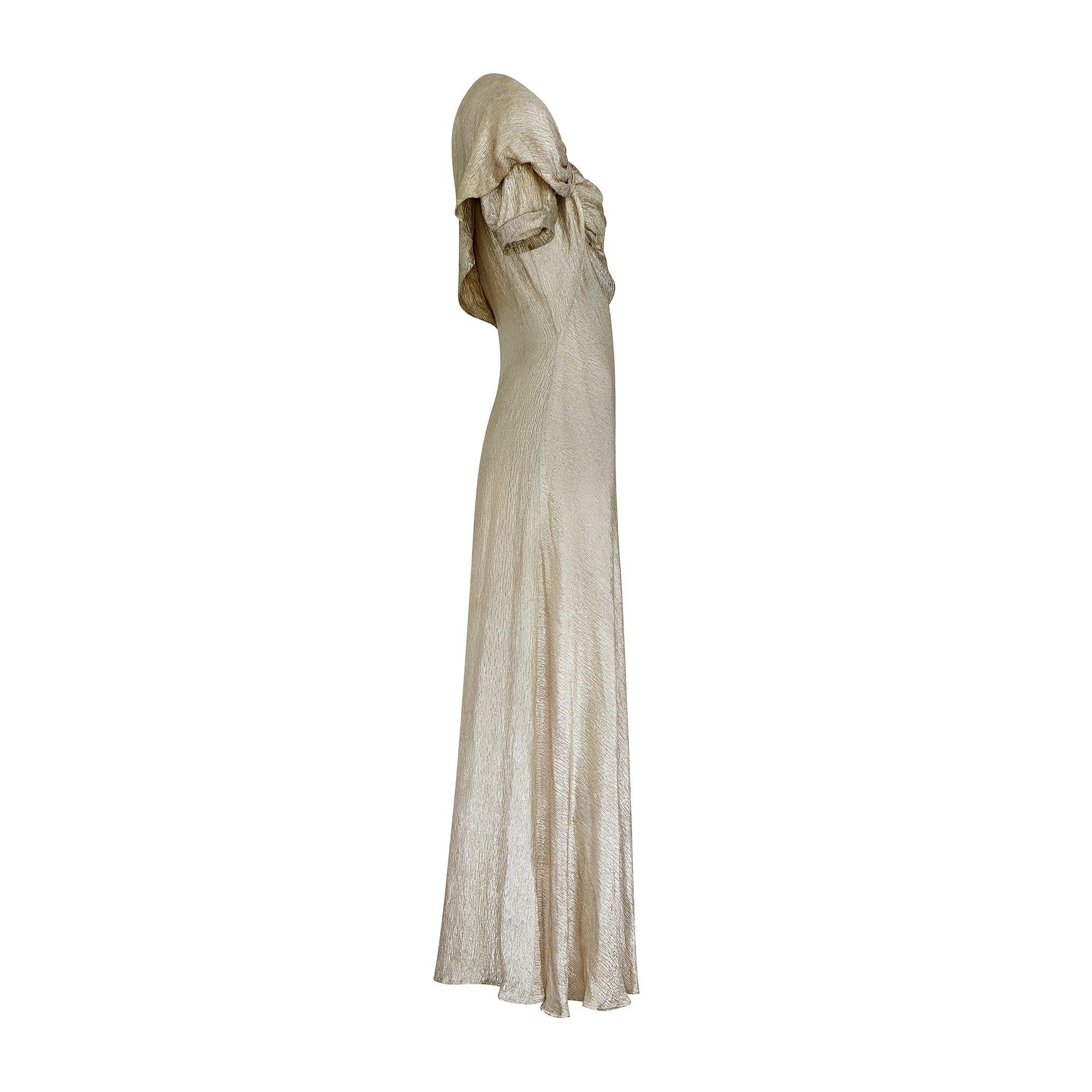 This 1930s gold lame maxi dress would be the crowning glory for any fans of 1930s clothing, or the perfect choice for an eye-catching and wearable gown for an upcoming event. It is crafted from shimmering pale gold lamé with a beautiful organic