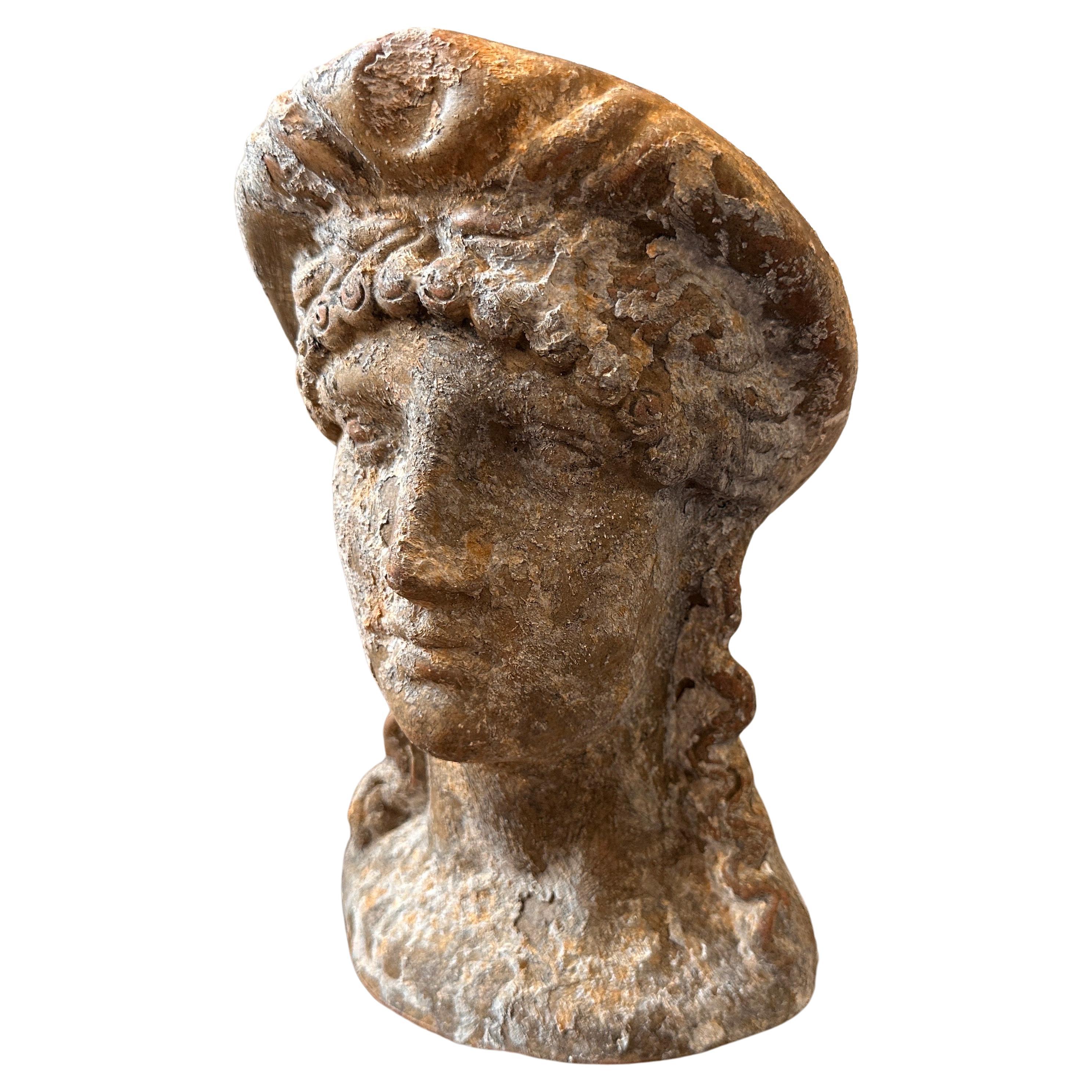 In the 1930s, during a period of artistic revival, a remarkable Greek Roman-style hand-crafted terracotta Sicilian woman head was created, showcasing the fusion of ancient Greek and Roman artistic influences with Sicilian craftsmanship, the