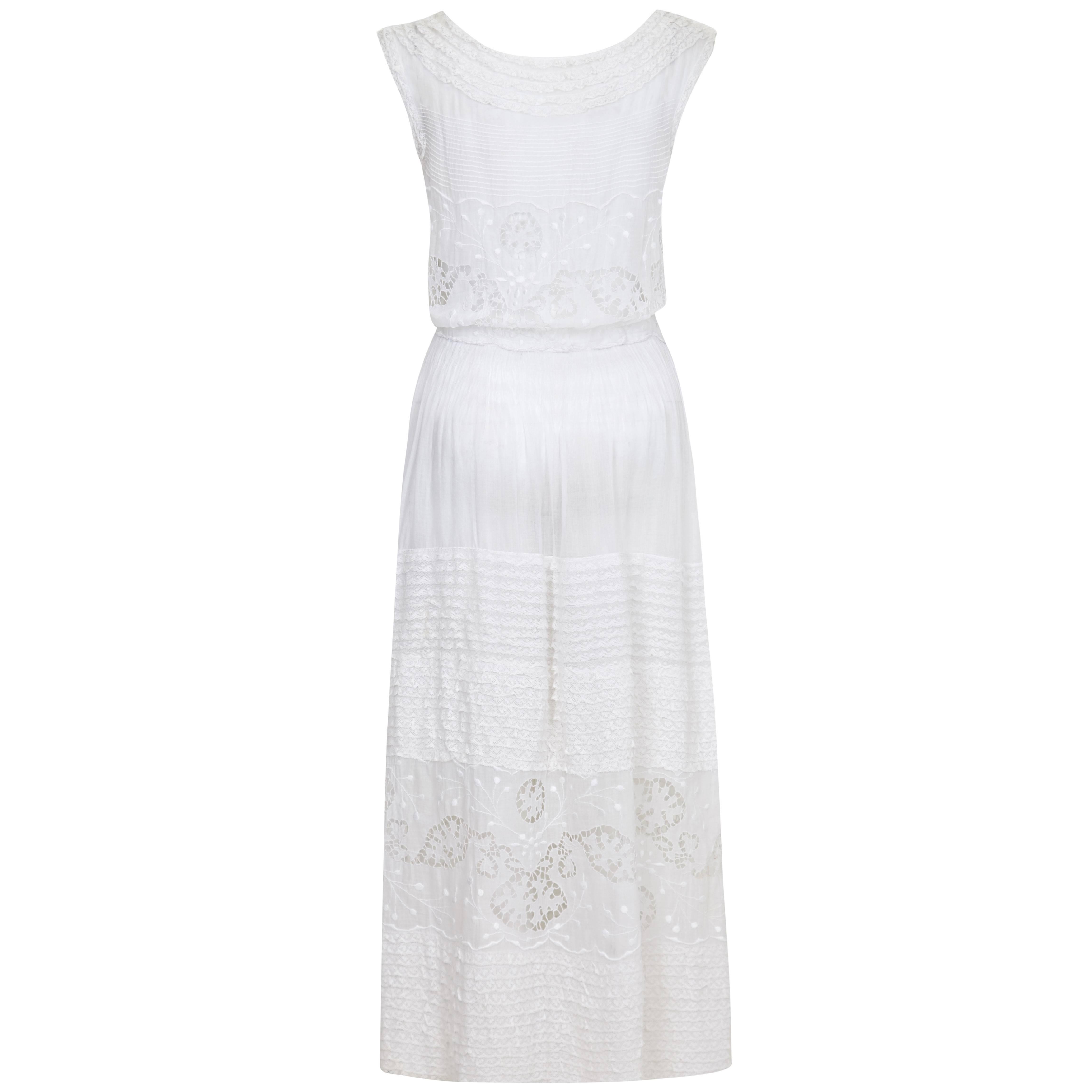 This enchanting rare handmade vintage 1930s white work dress in delicate white cotton showcases incredible eyelet work, embroidery, pin tucks and lace overlays and is in beautiful vintage condition. The dress is a simple shift cut with a gentle