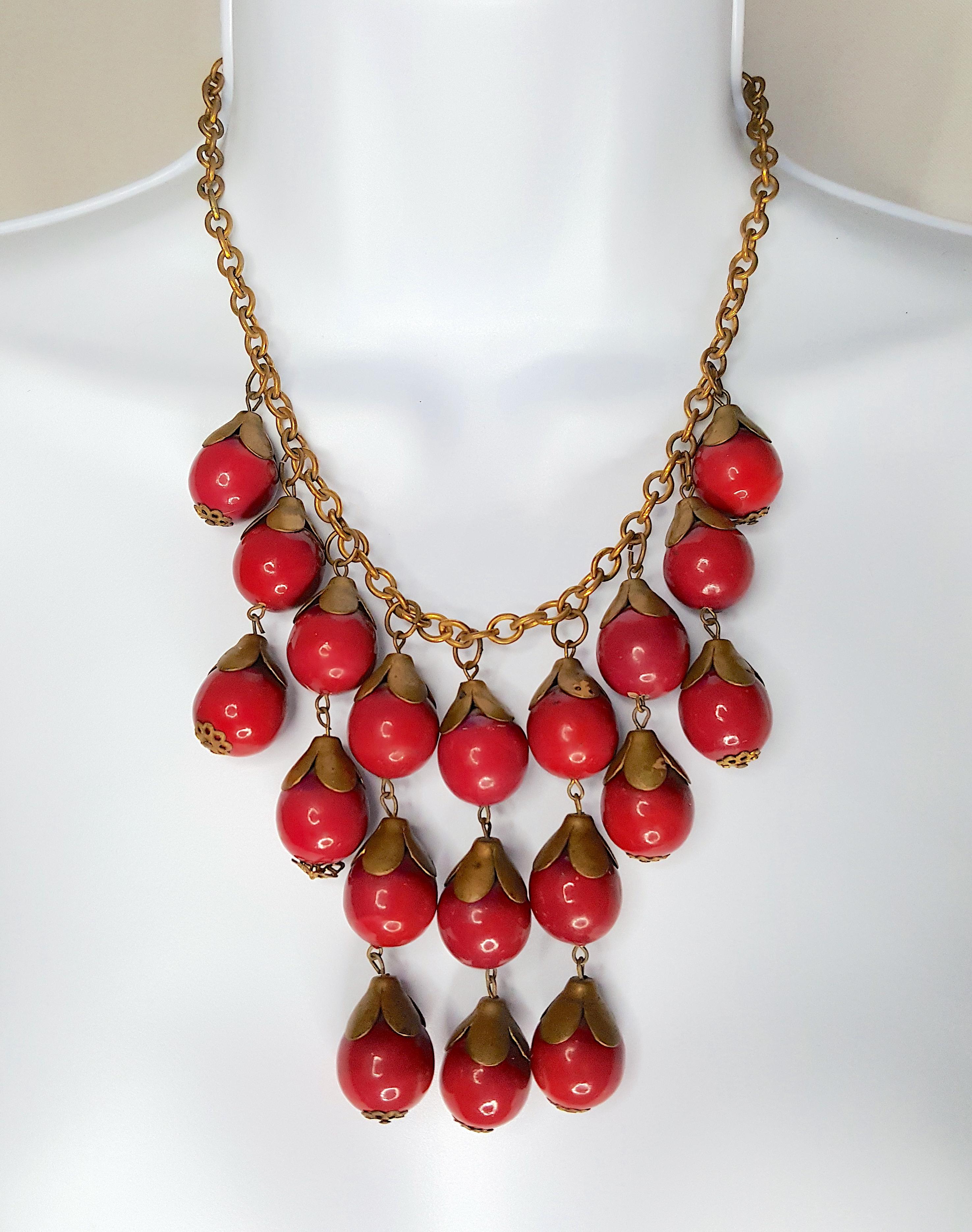 With an organic flora motif characteristic of American Miriam Haskell's first designer Frank Hess, this 1930s Russian-gilt brass oval-link chain necklace features a tiered bib of free-hanging various-length strands of fruit-like red-enameled beads