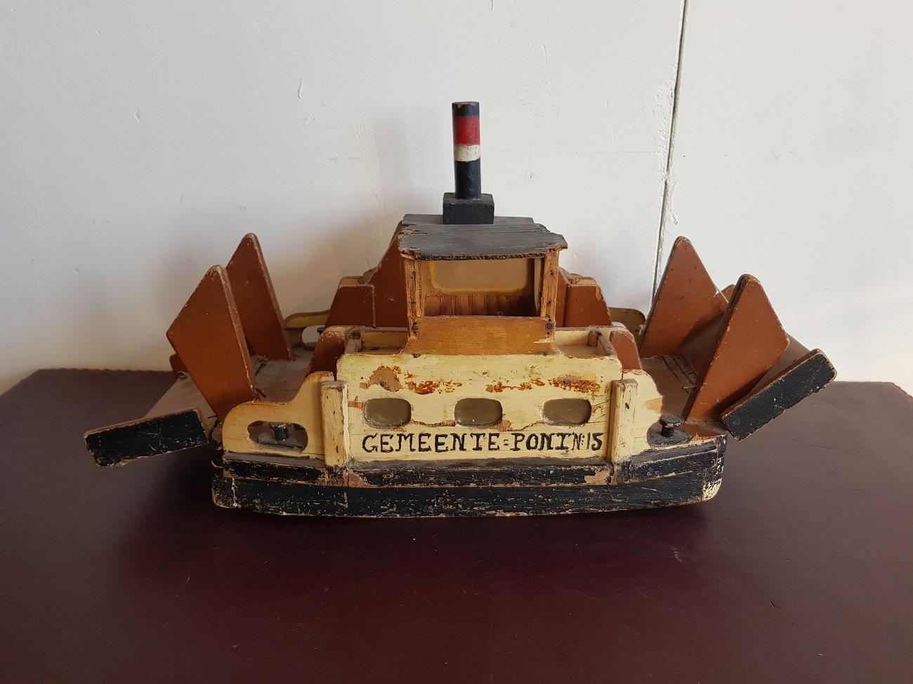 Old homemade wooden toy steam ferry with the text 