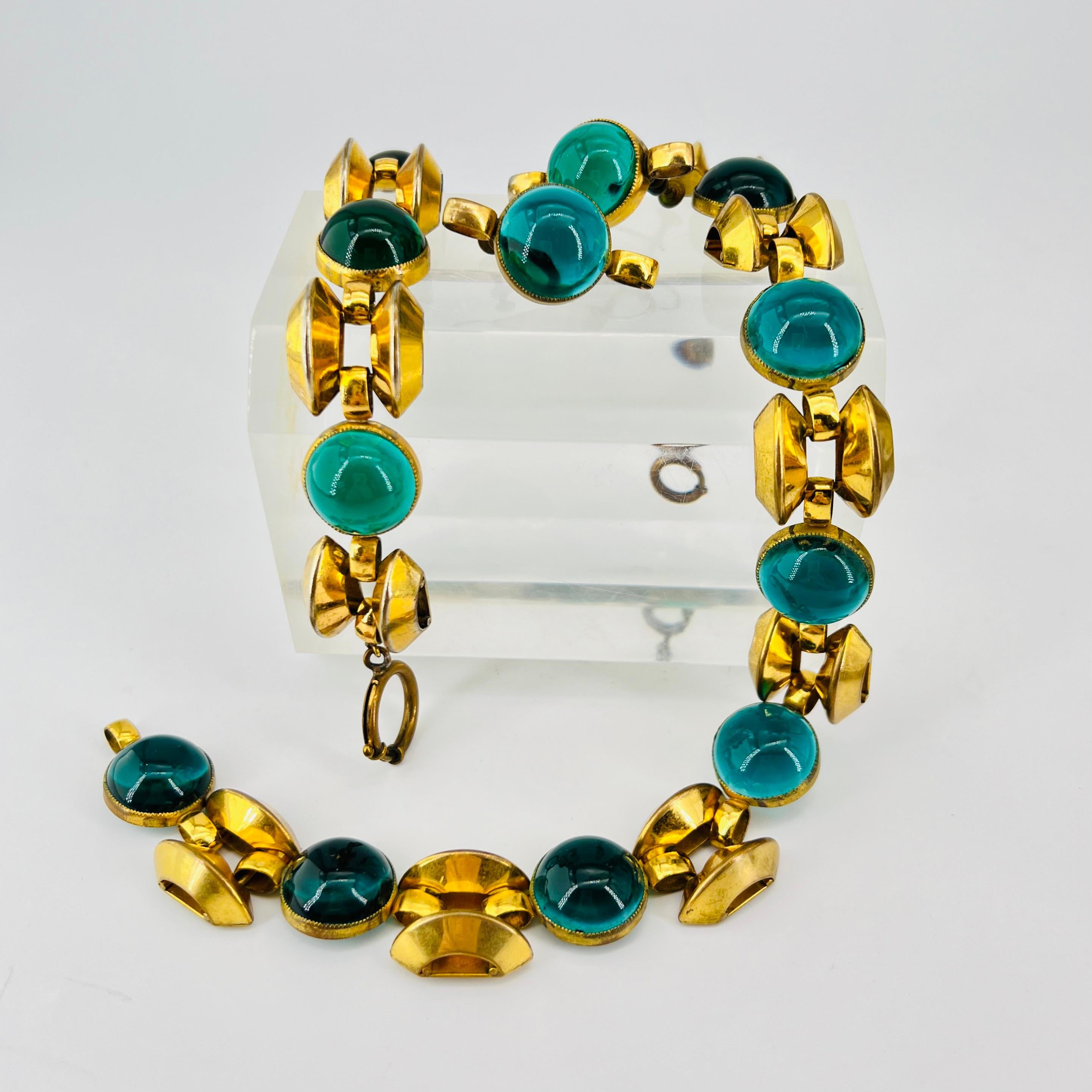 The Decadence of Early Haute Couture released by the hands of Elsa Schiaparelli.  Early 1930’s -1940’s House of Schiaparelli Studio in France. A Parure Set with Matching Necklace, Bracelet, and Screw on Earrings. Golden Art Deco Motifs & Green Glass