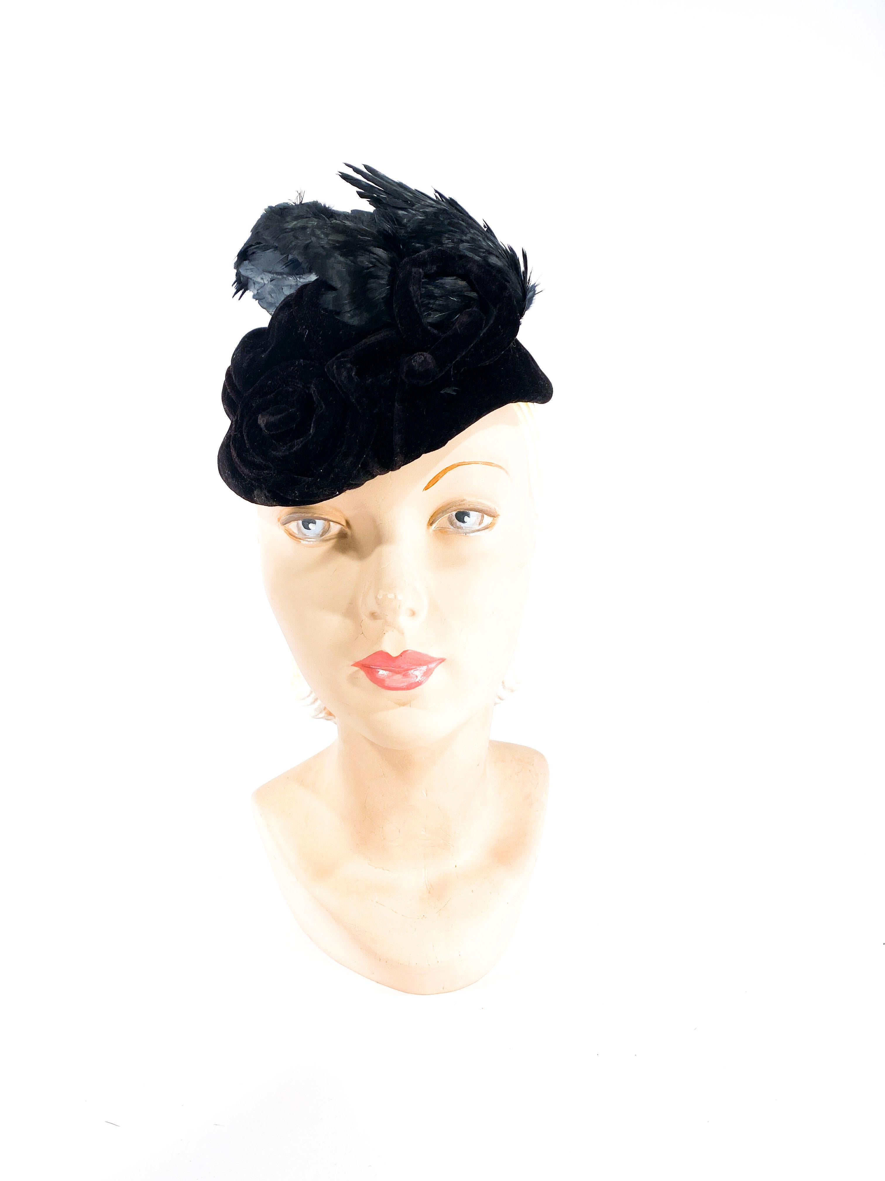 Early 1930s I. Magnin hand-sculptured black velvet perch hat with enlarged piping details though out the base of the hat in circular designs. The hat is finished with very large doubled bird wing feathers that decorated the entire top of the hat. 