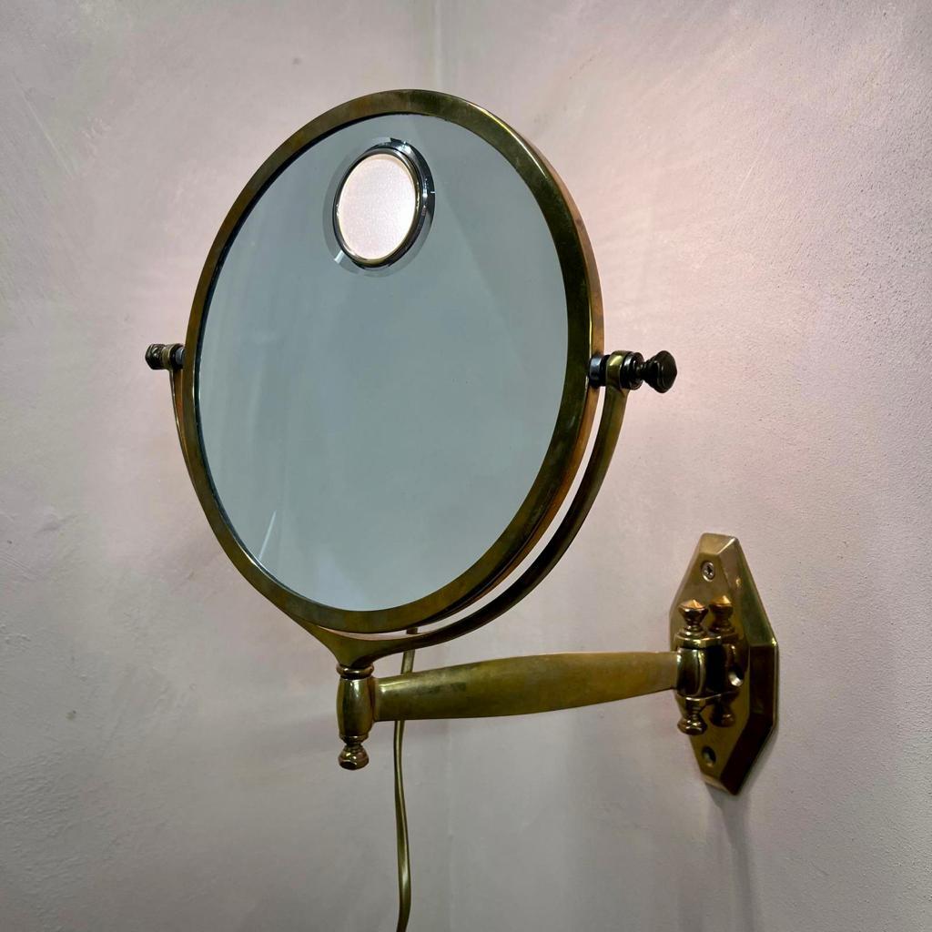 French Art Deco illuminated wall barber´s mirror by Miroir Brot, Paris. This historic company was established in 1826 by Francois Brot, mirror maker to King Charles X. 
The design of this illuminated mirror was created in 1927.
A magnifying mirror