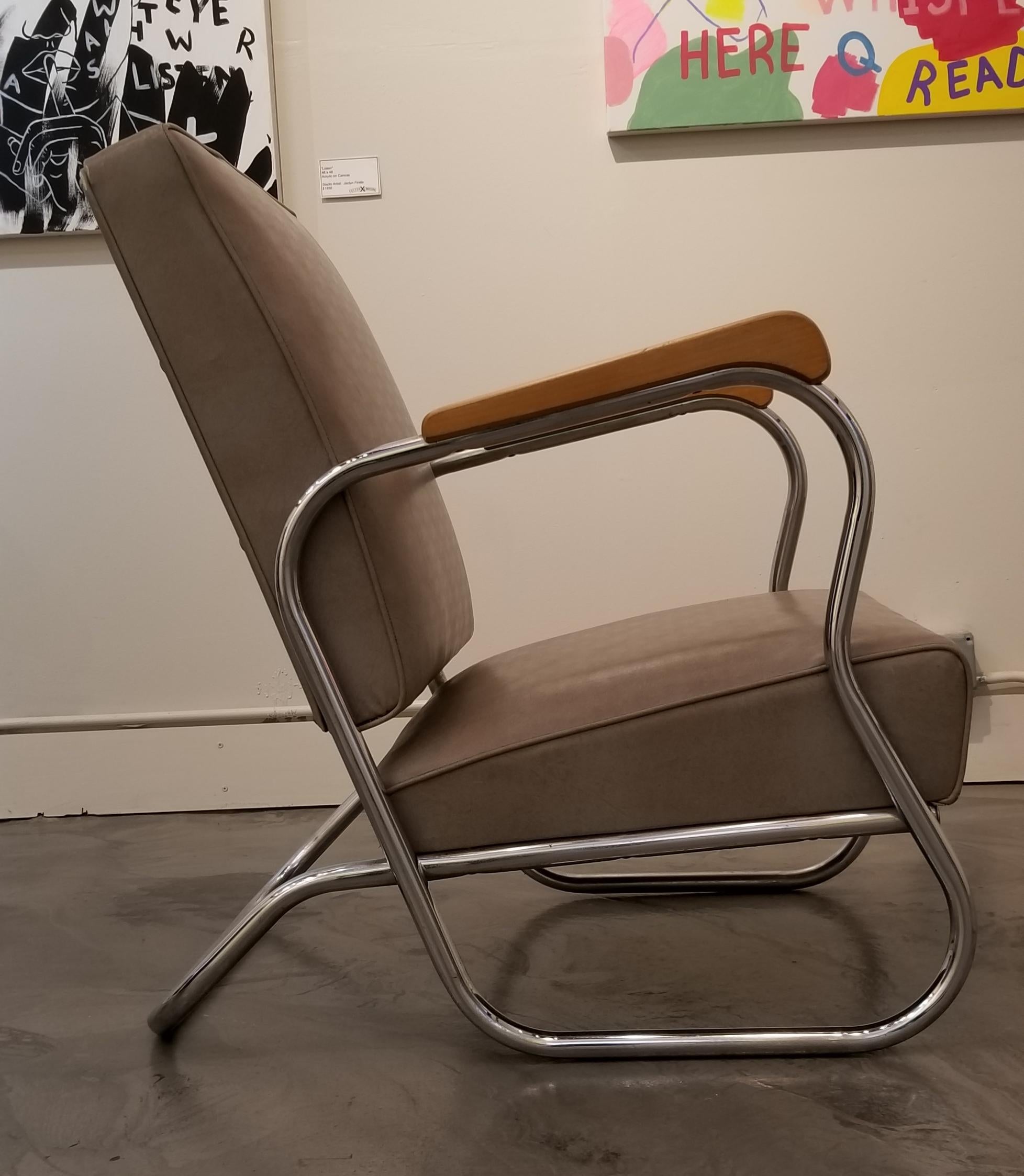 A solid pair of industrial design tubular steel, polished chrome club chairs from the 1930s. In the manner of K. E. M. Weber or Wolfgang Hoffman, but are by an unknown designer. Structurally very solid chairs. Original sculpted wood armrests.