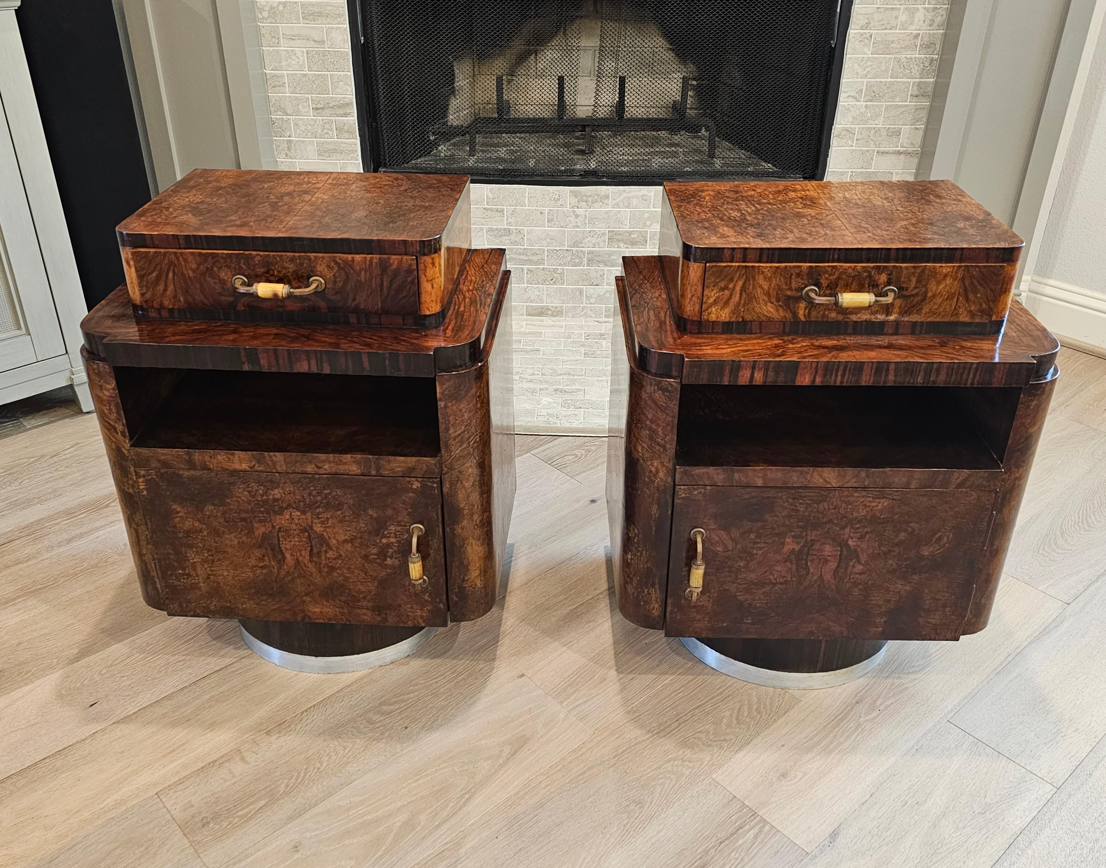 A visually striking pair of original Italian Art Deco burlwood bedside tables (nightstand - end table). Featuring the brilliant contrast of smooth rounded edges, sharp angles, and rich exotic materials the Art Deco period is renowned for!

Born in