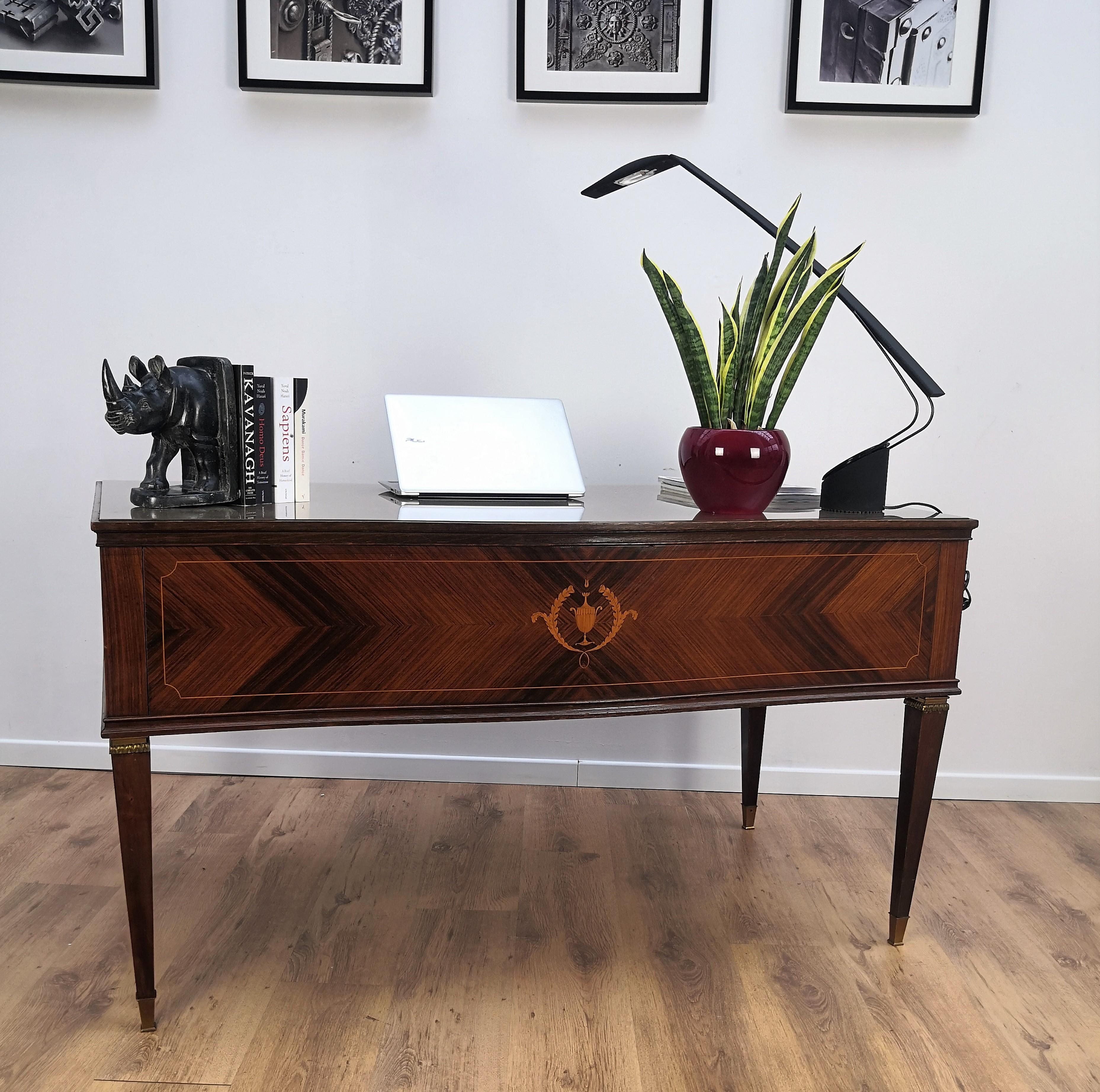 Beautiful Italian 1930s writing desk, bureau with elegant and classic wood worked according its natural graining, 4 drawers with gray/copper lacquered glass top and the final touch details of the original gilt brass handles and gilt brass feet on