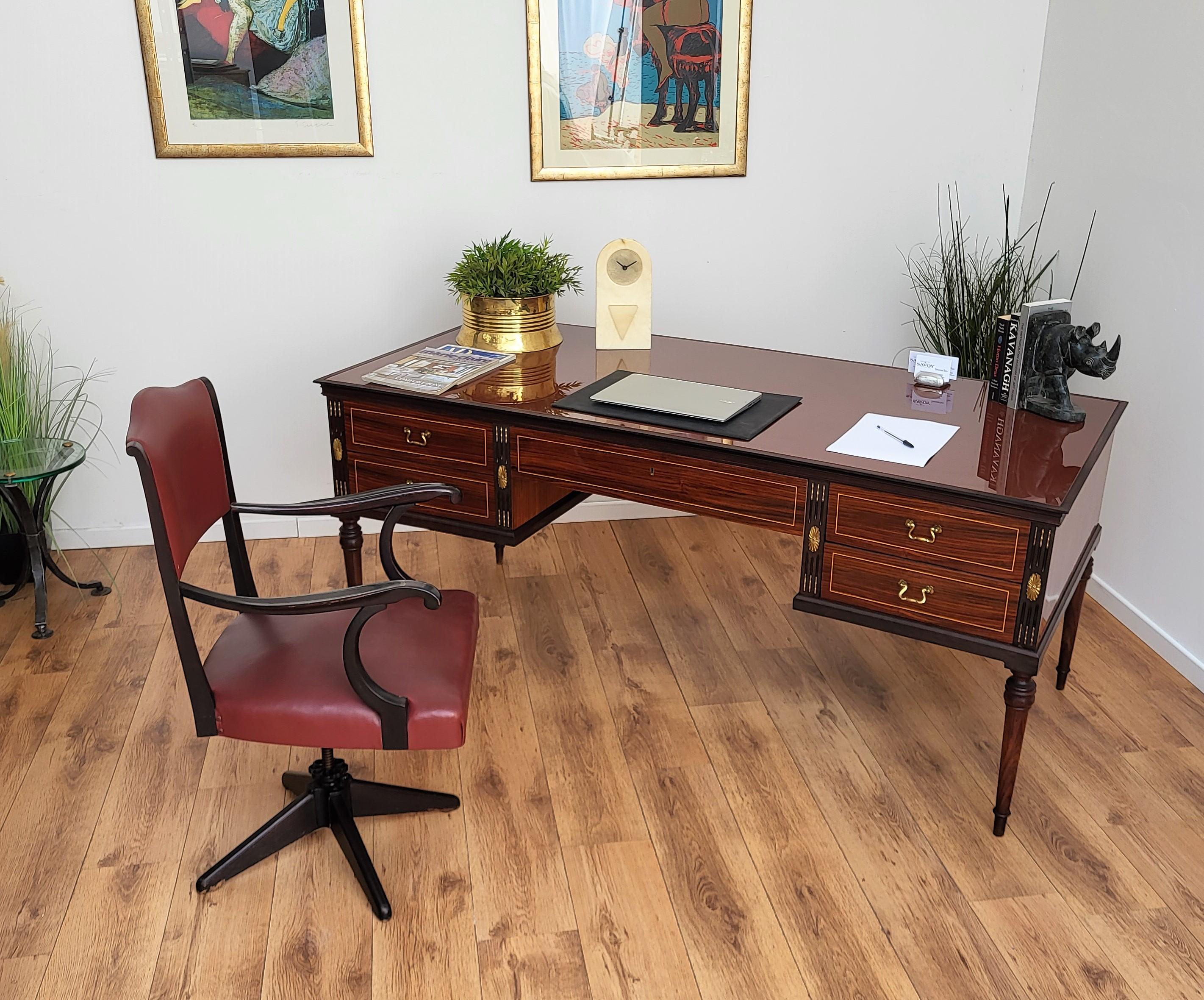Beautiful and important Italian 1930s writing desk, bureau of huge dimensions with elegant and classic wood worked according its natural graining, 4 side and one central drawers with bordeaux lacquered glass top and the final touch details of the