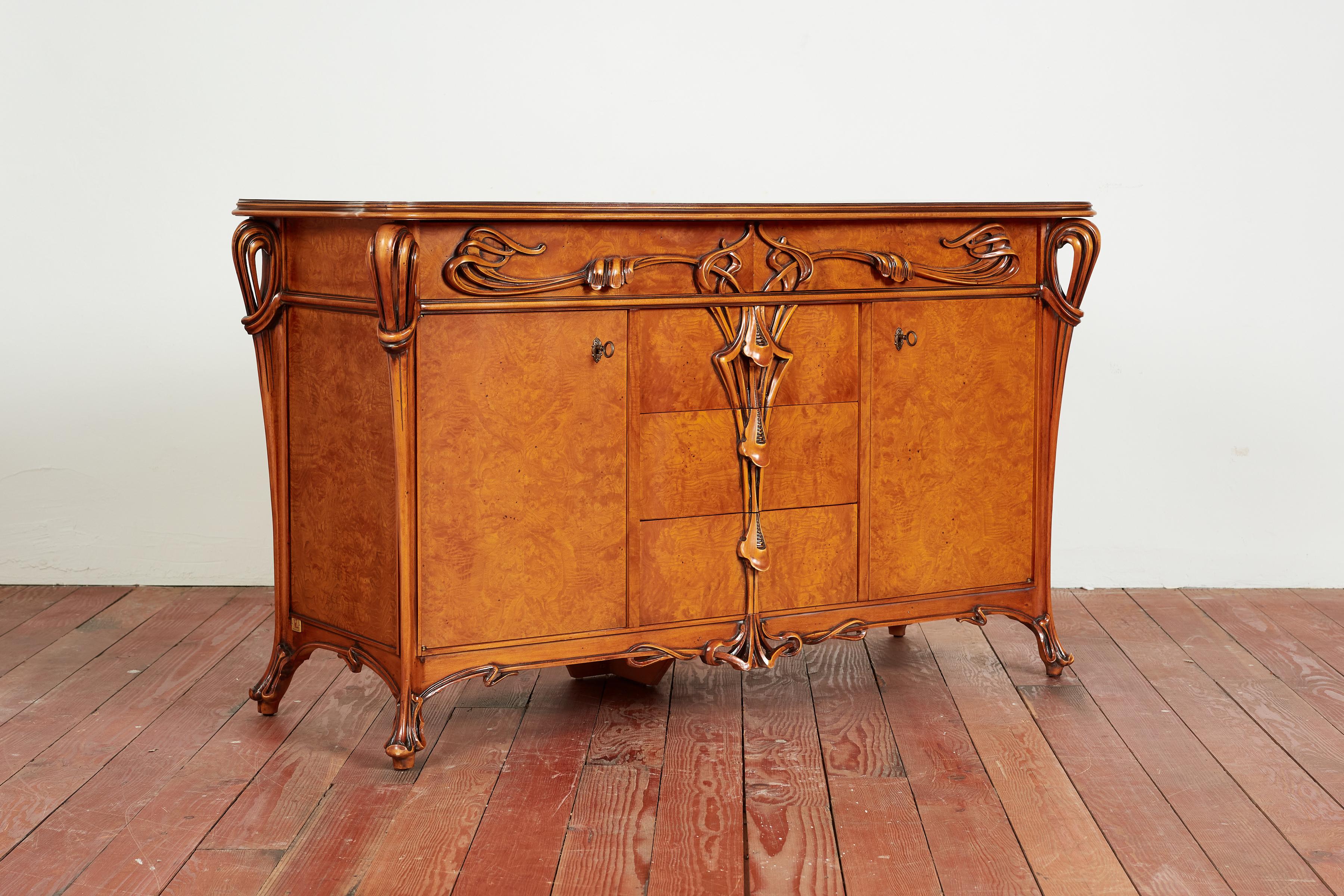 Italian Art Nouveau dresser / cabinet constructed of Burlwood with exquisite carved detail throughout. 
Two drawers along with three center drawers with curved carved handles 
Two cabinet doors open to reveal adjustable shelf. 
Original Italy brass