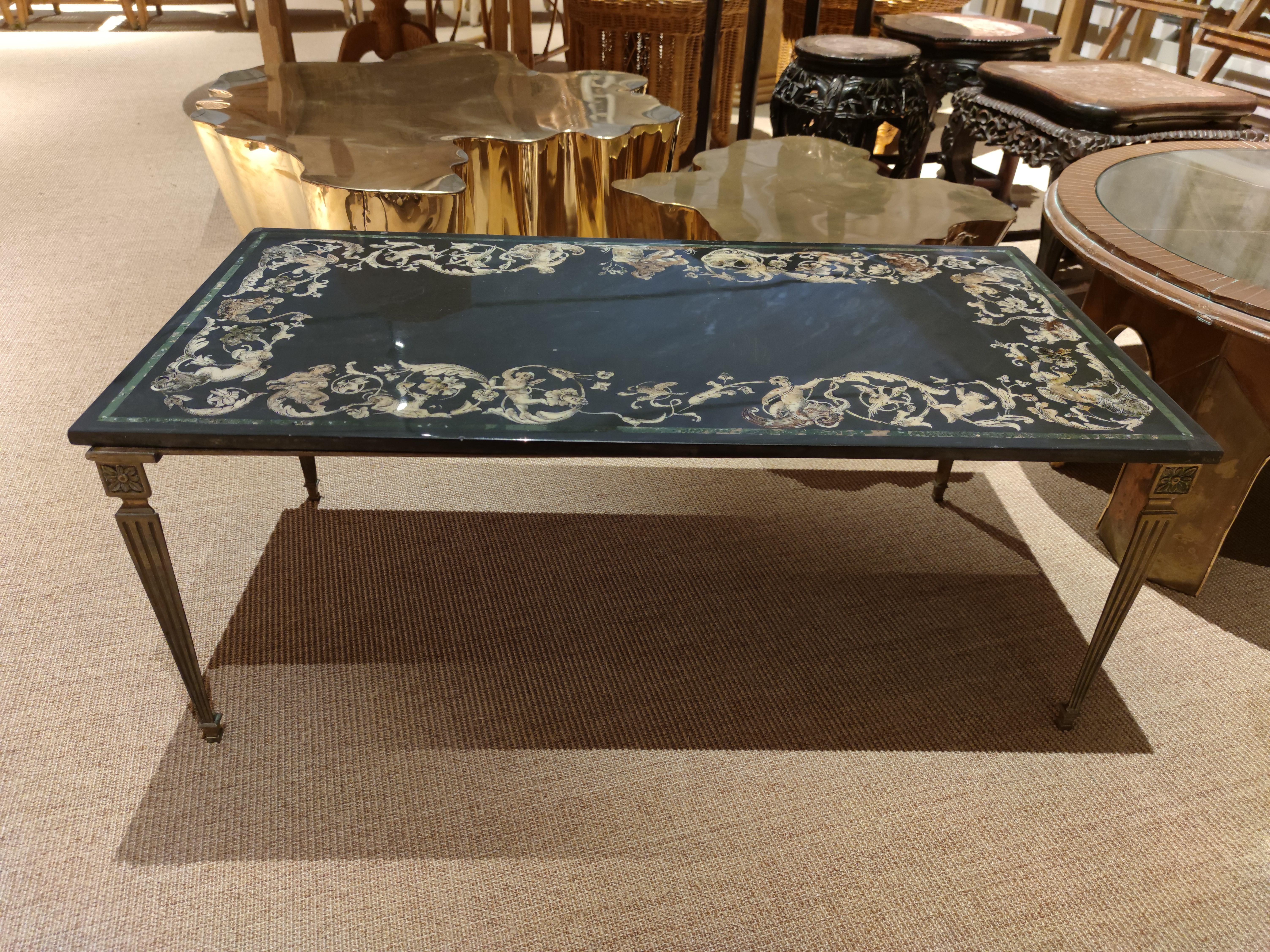 table basse en marbre Nero italien des années 1930, encadrée d'une marqueterie de stucs ornementaux végétaux et humains.

  