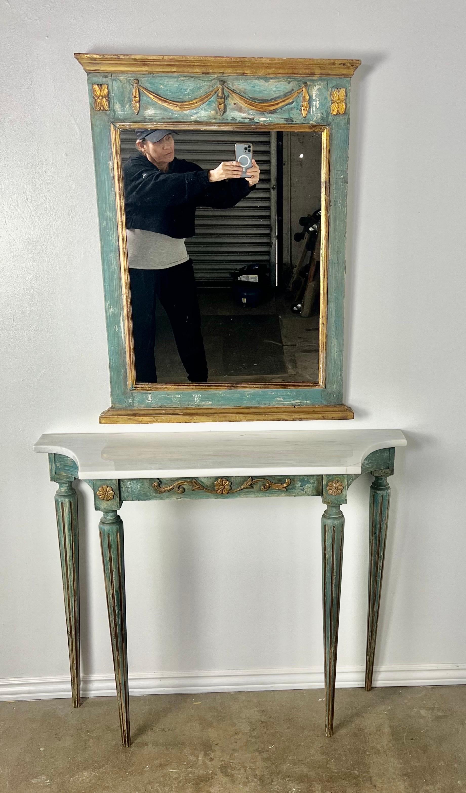 Italienische Konsole aus den 1930er Jahren, bemalt, mit passendem Spiegel.  Die Konsole steht auf vier kannelierten Beinen und hat eine Steinplatte.  Sie sind in einer blau-grünen Färbung gehalten.  Die Farbe ist schön abgenutzt, so dass der Gesso