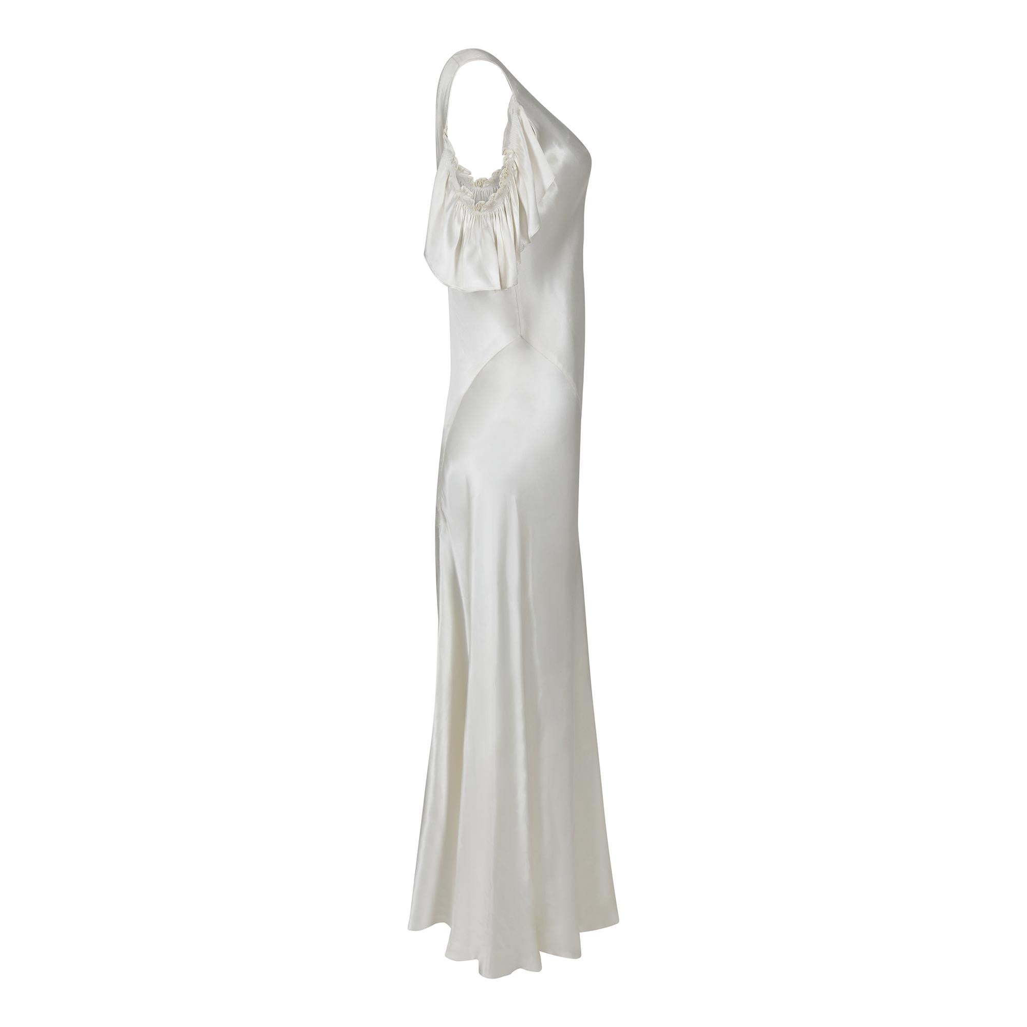 This original 1930s ivory satin wedding dress is a very wearable and has well executed bias cut panels showing considerable pattern and cutting skills. The satin is a bright and shiny ivory colour. The V neck has little bust darts for shaping and