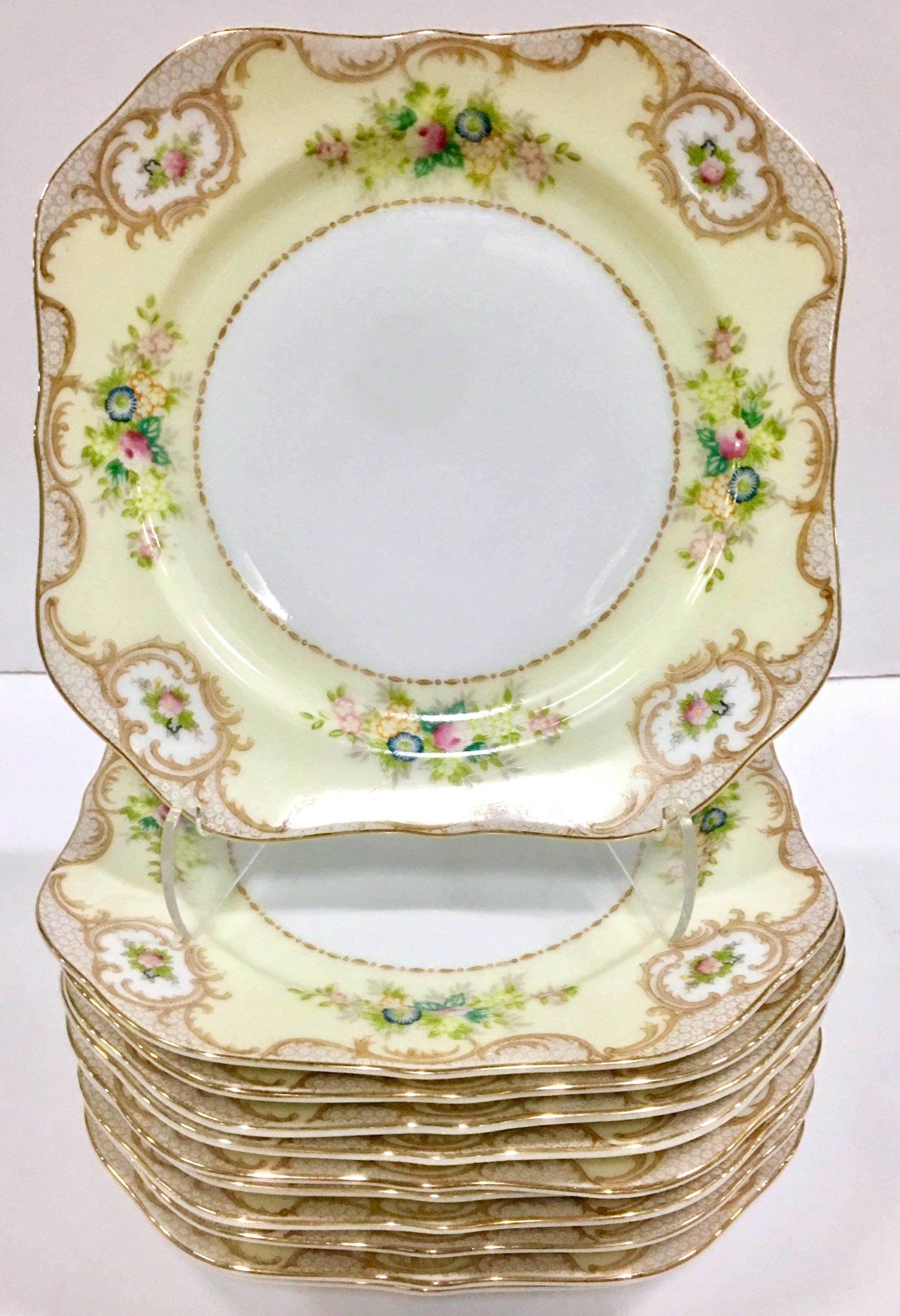 20th Century Art Nouveau hand-painted Japanese porcelain dinnerware set of 17 pieces by Meito. Pattern features a white ground with a butter yellow border, decorated with 22 Karat gold scrolls and rim, blue, pink and yellow floral bouquet. Set