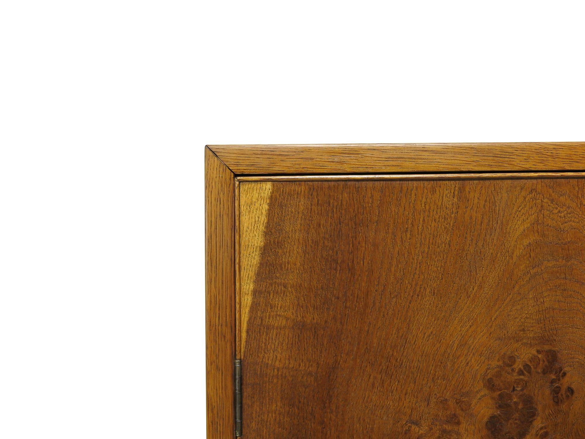 Armoire scandinave traditionnelle fabriquée à la main à partir de chêne, présentant un grain spectaculaire assorti aux livres sur les deux façades des portes verrouillées, placées au-dessus de deux tiroirs verrouillés avec des ferrures en laiton.