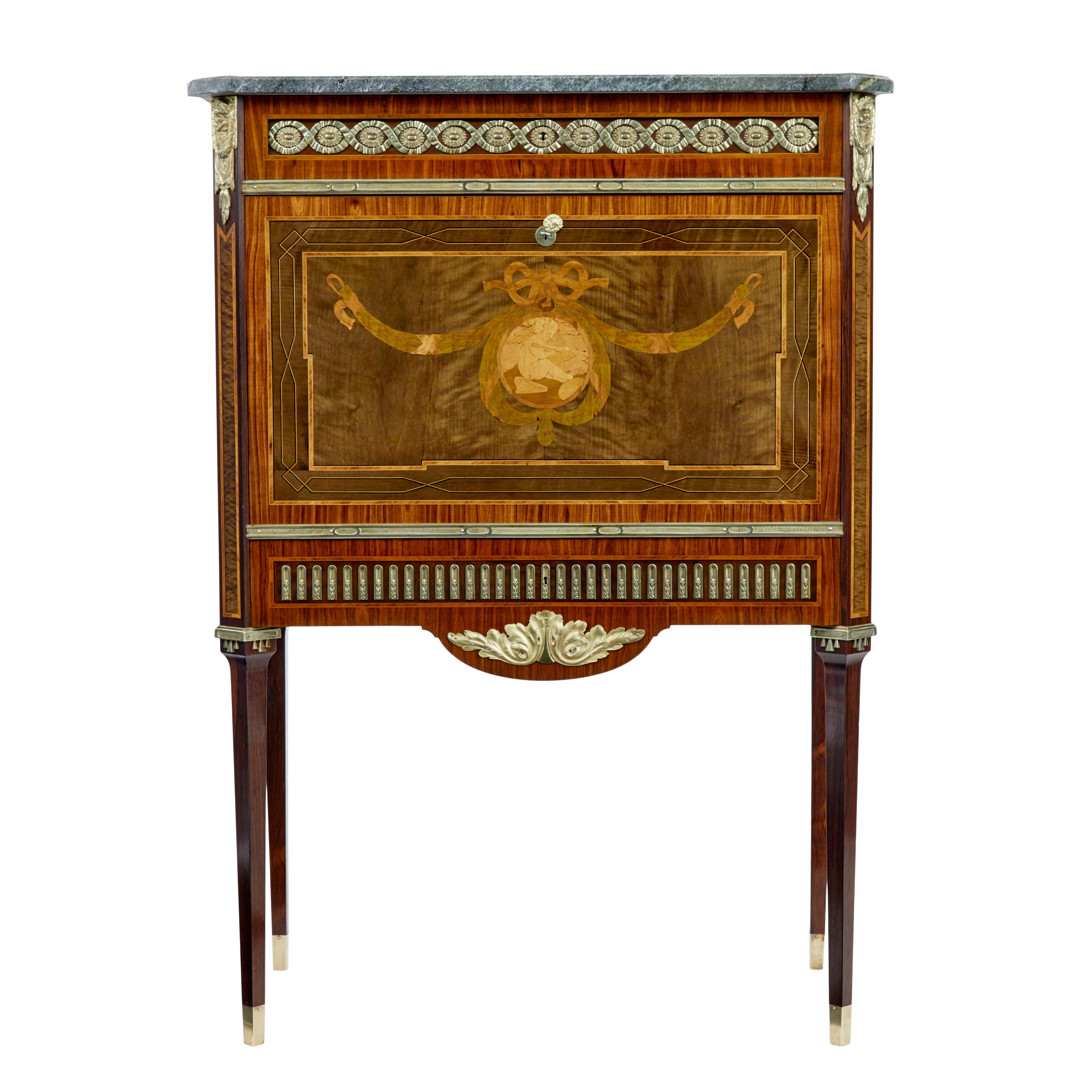 Good quality inlaid secretaire circa 1930.

Over-sailing grey marble top with canted corners.  Single drawer below the top surface cross banded and with ormolu mounts.  Profusely inlaid fall drops down to a writing height of 28 3/4