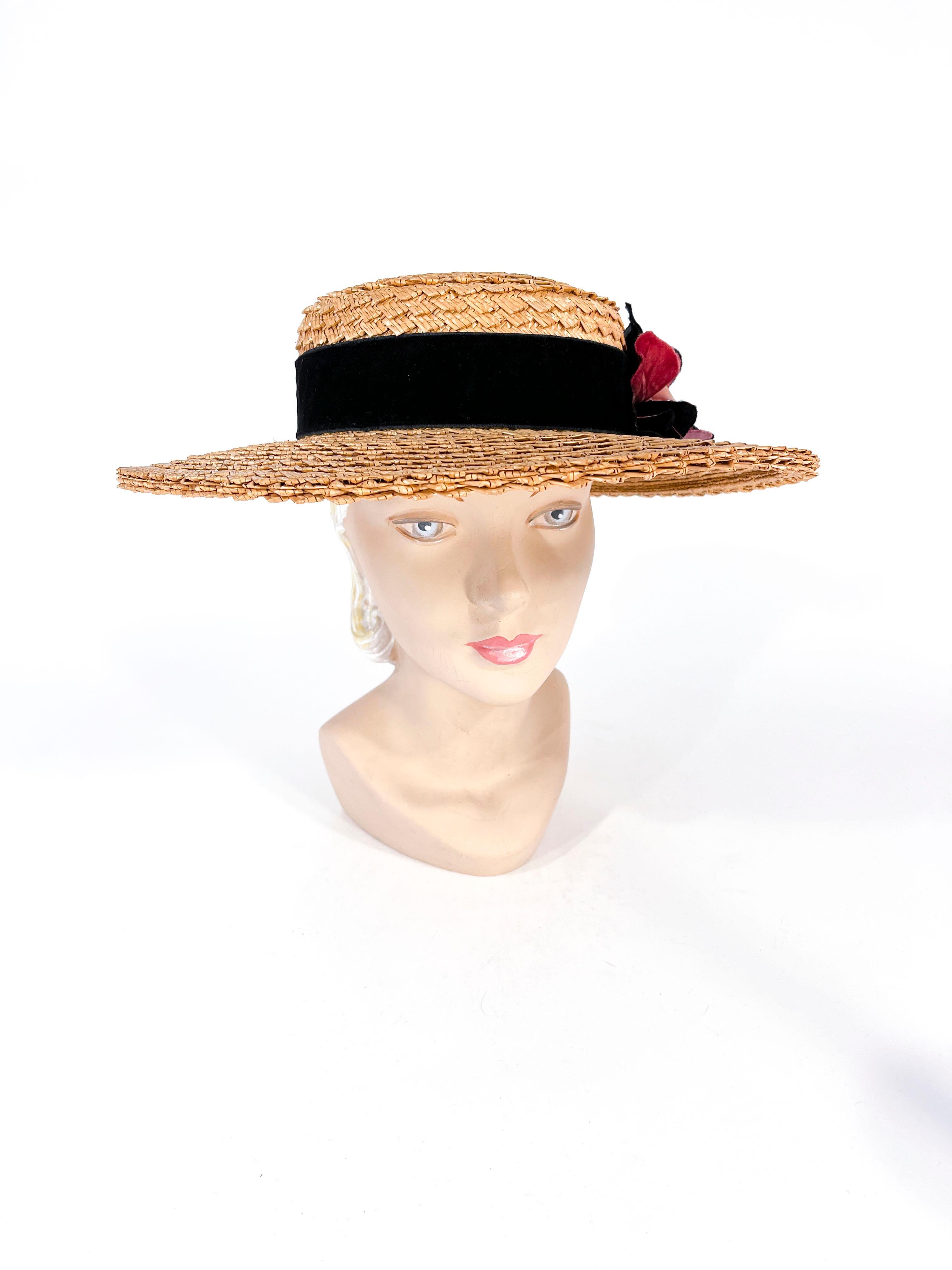 1930s ladies handwoven straw skimmer decorated with a wide black velvet band. The band is finished with handmade multi-colored silk and velvet flowers. The interior of the crown is unlined and finished with a grosgrain band. The interior