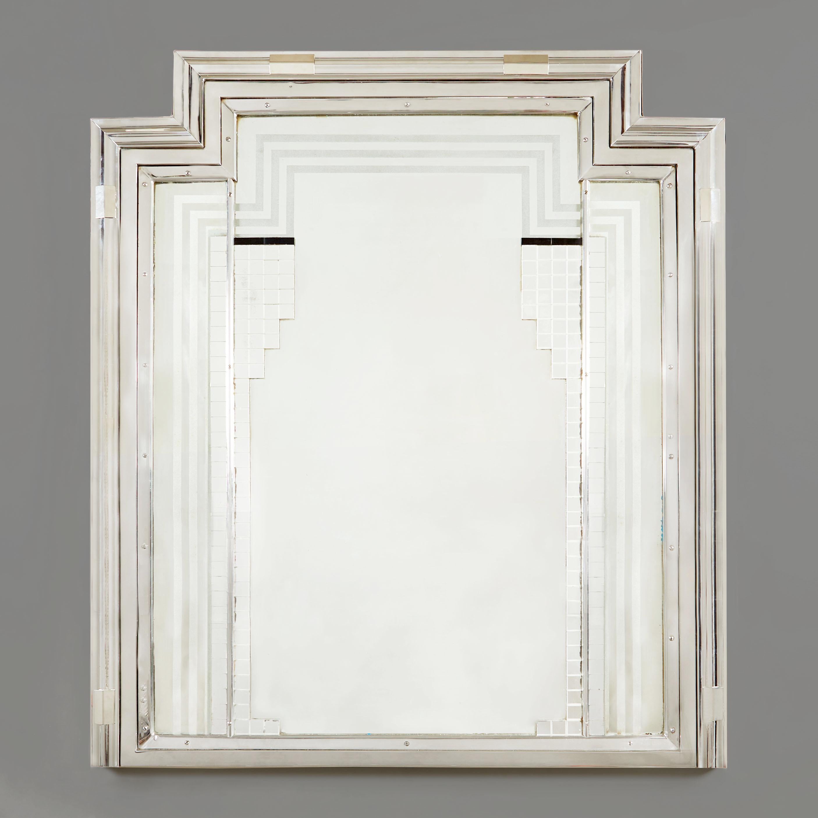 Stunning and rare circa 1930s Art Deco mirror with substantial stepped chrome frame. Richly detailed with classic deco shapes, including etched lines and layered square silver and black glass tiles forming a geometric pattern.

Provenance: By