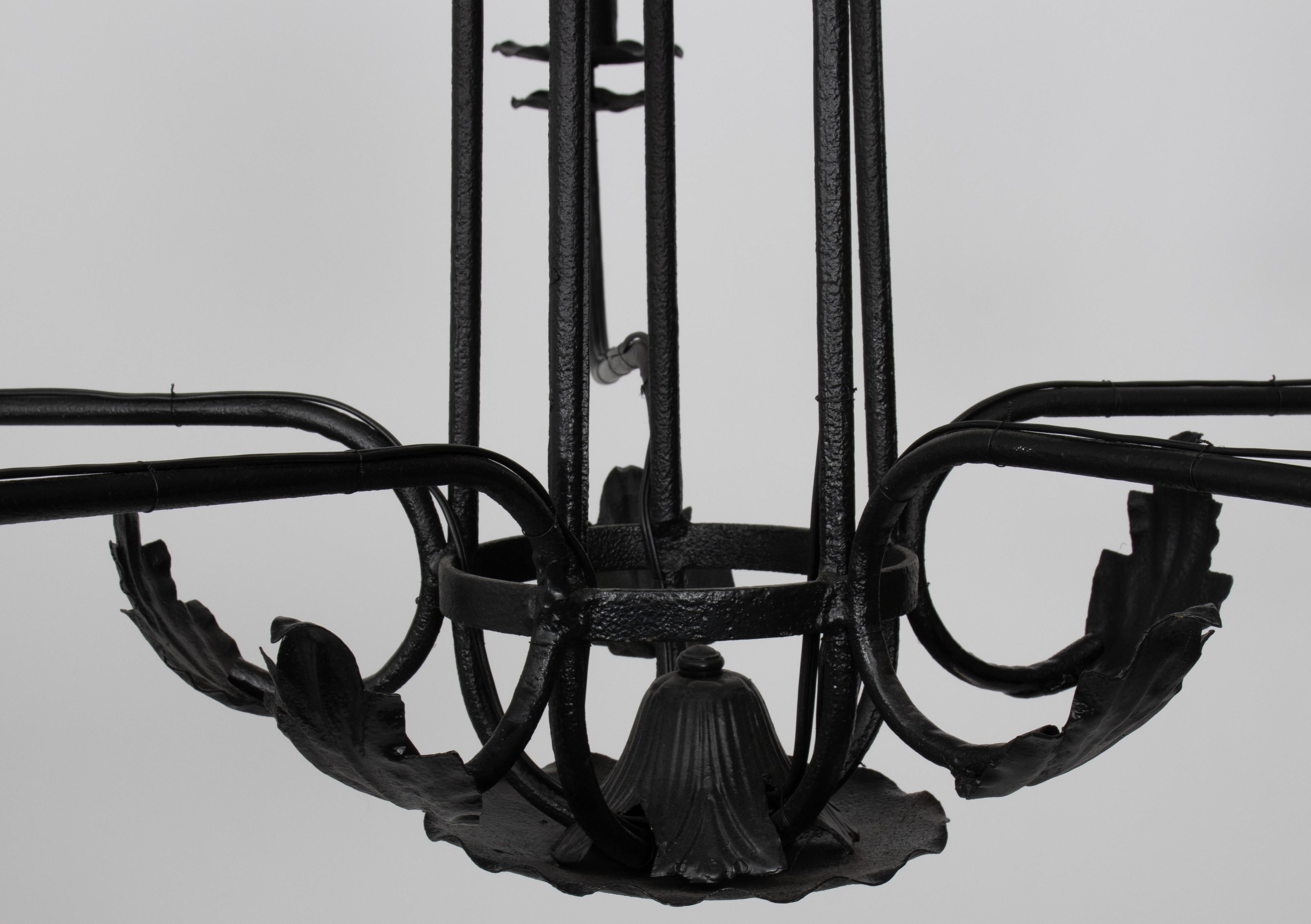 Large 1930s black wrought iron chandelier with leaf detailing. Newly painted in satin black finish. 12