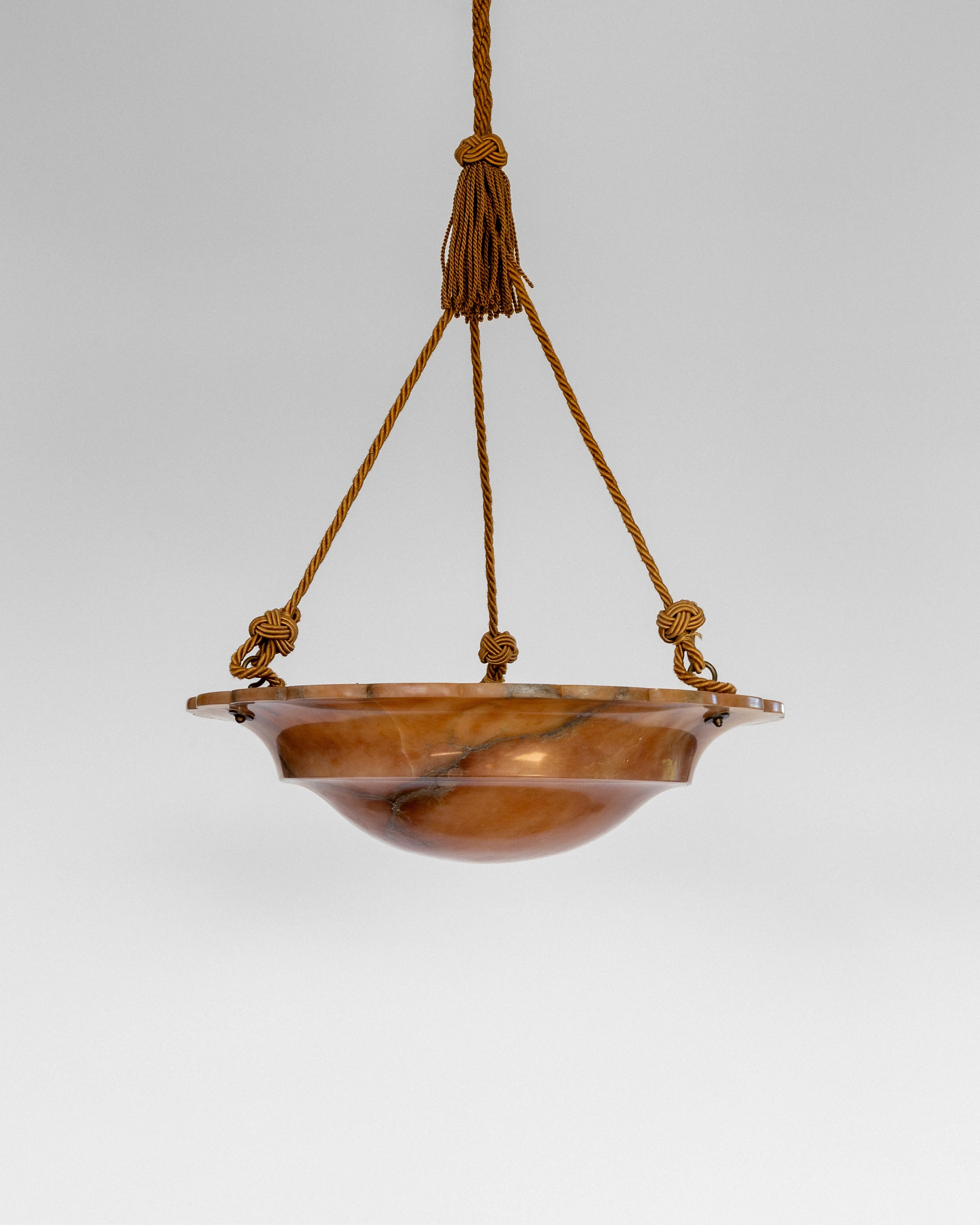 A large, majestic three light alabaster pendant from the heydays of the Art Deco era in Sweden. Hand carved natural stone with hues of orange, beige and brown. Very pleasant Neoclassical design with scalloped brim and original rope and canopy.

The
