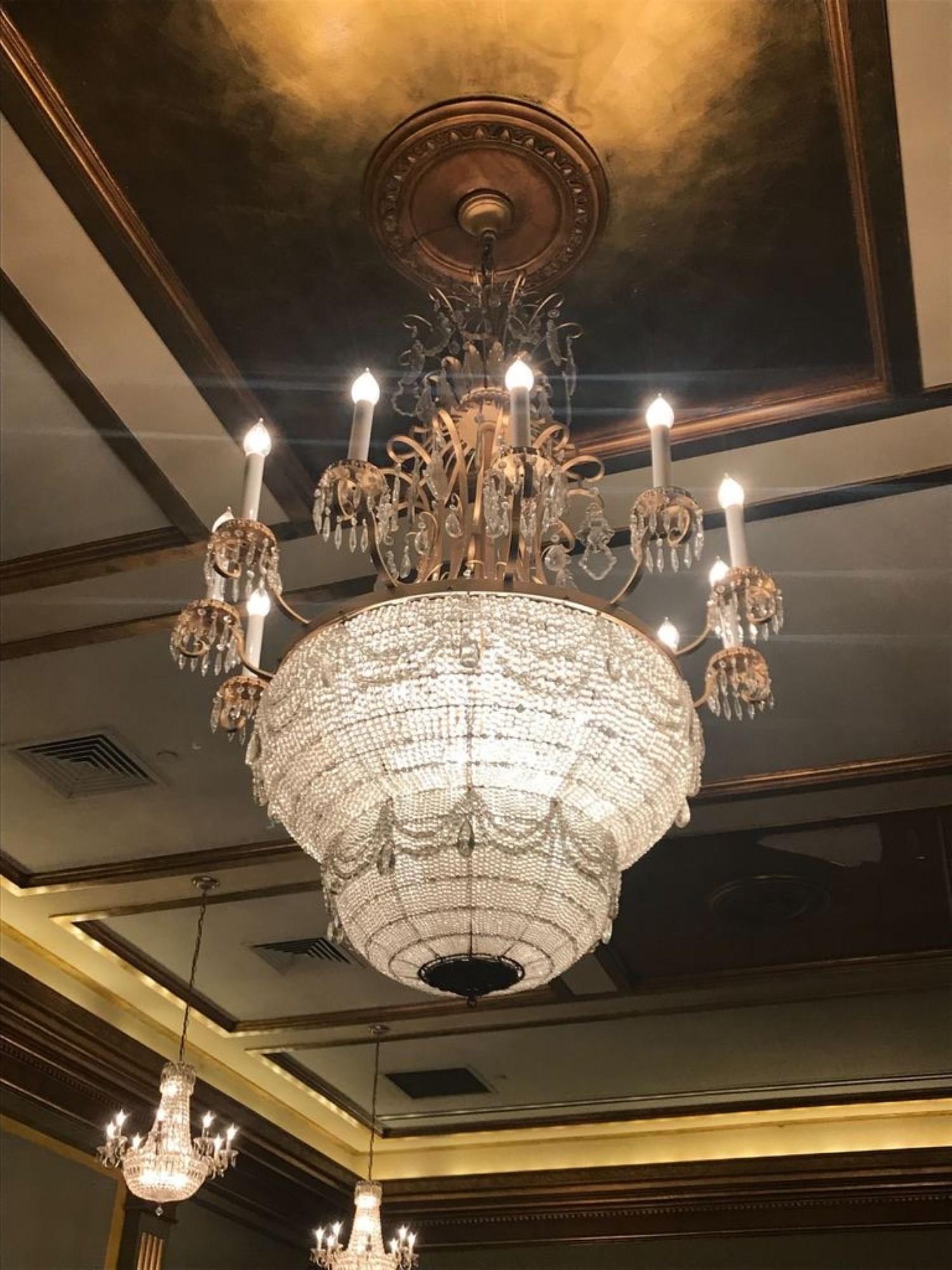 Impressive large scale crystal basket chandelier from the 1930s. There are 12 candlestick arms outside and 18 bulbs on the interior, with 30 lights total. Form The Palace Theater in Manhattan. Small quantity available at time of posting. Please