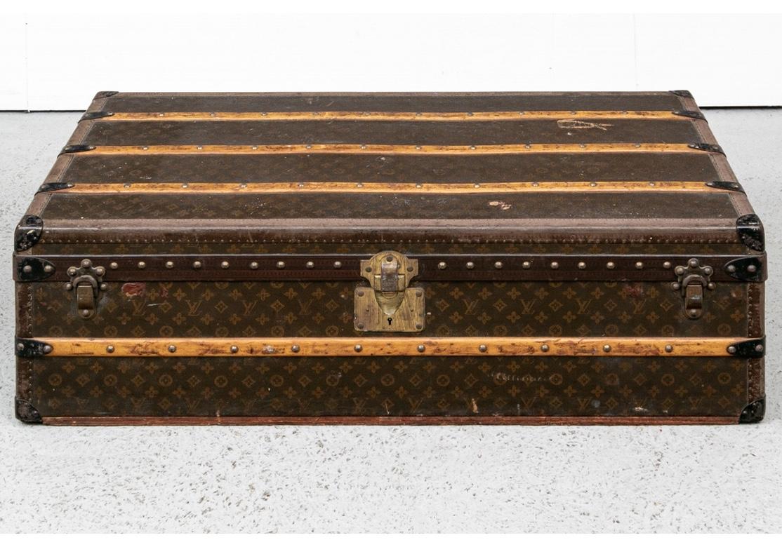 A well worn and well-used Vuitton Cabin Trunk from the Golden Age of Travel bearing the marks, tears and losses of a well-travelled piece. Worn label inside numbered 801359. The fabric lined interior with quilted lid and lift out shelf and ties