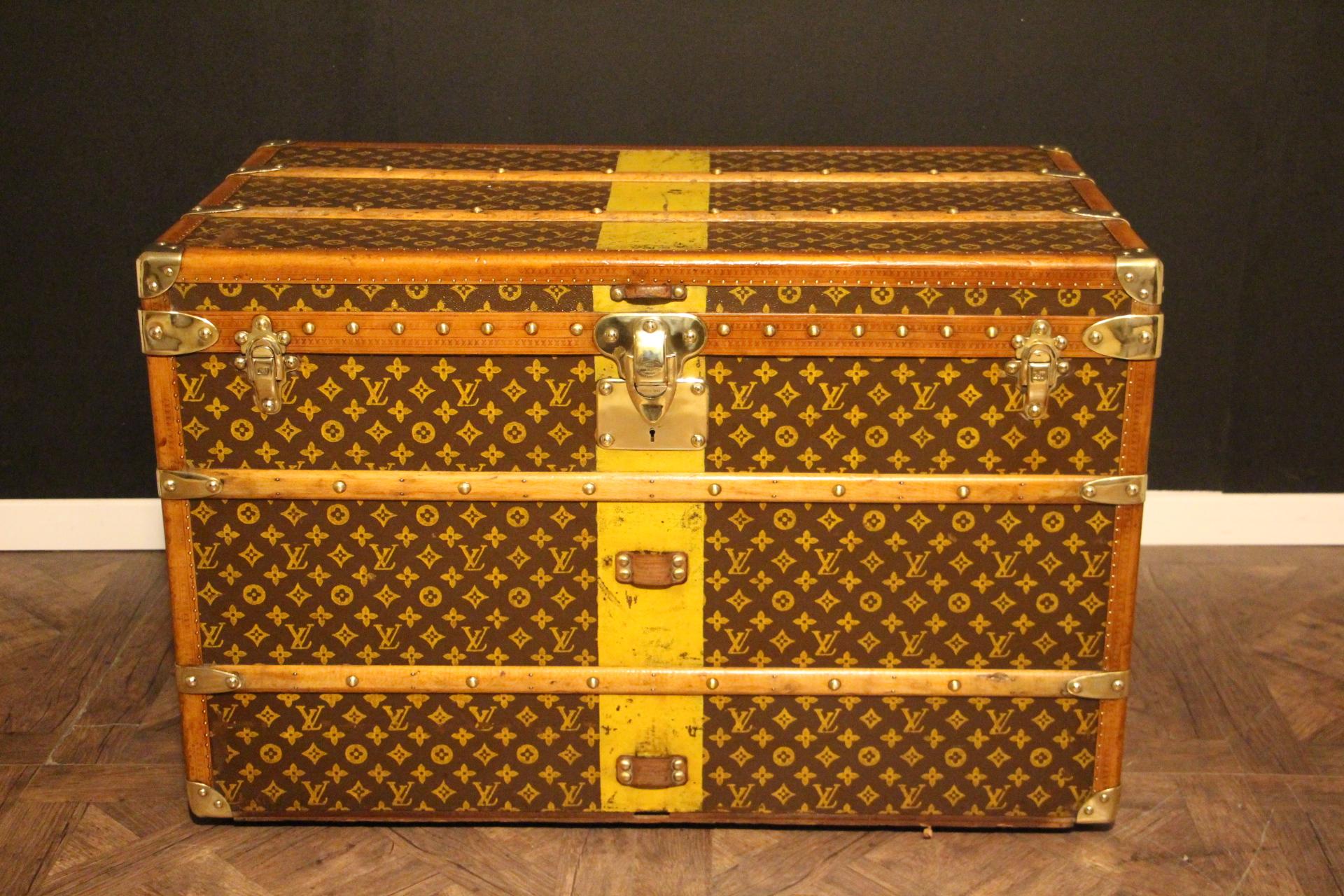 This superb Louis Vuitton steamer trunk features stenciled monogram canvas,honey color lozine trim, LV stamped solid brass locks and studs as well as leather side handles and brass corners. Its customized painted yellow stribes add a touch of